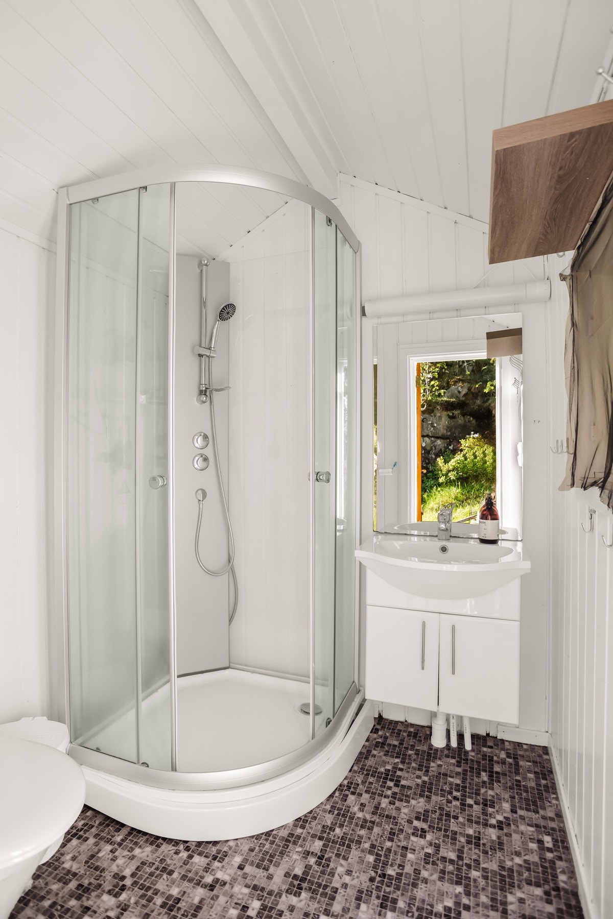 Badet er utstyrt med dusjkabinett, servant og toalett. Galleribilde