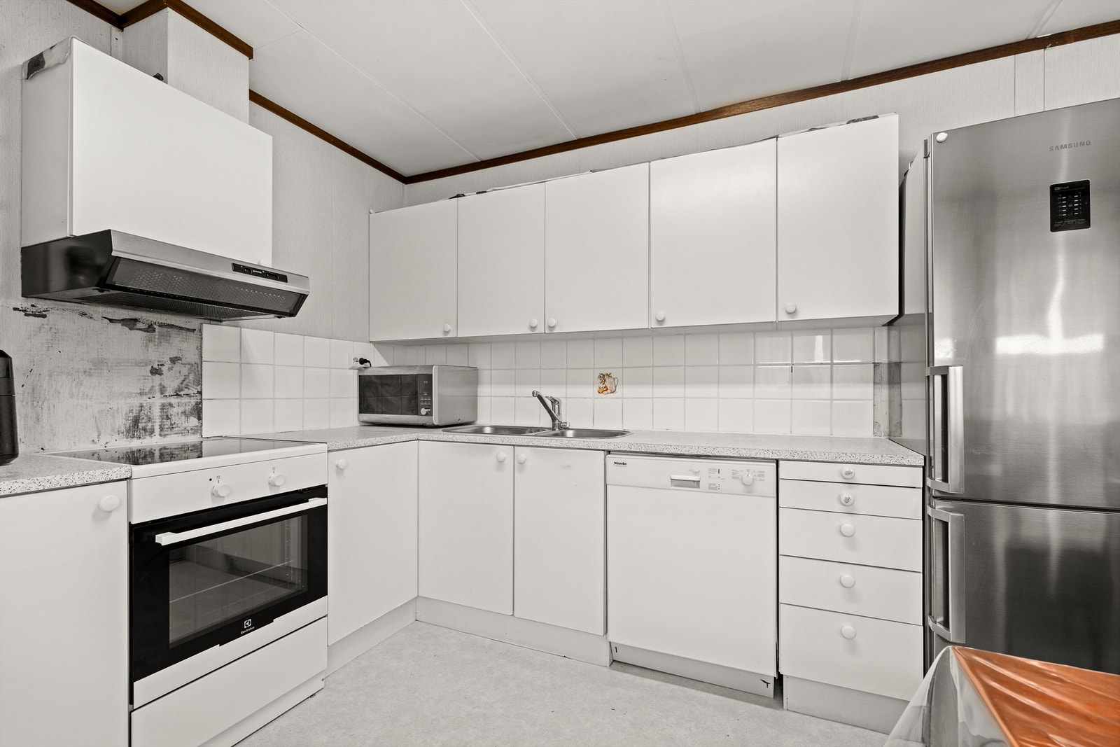 Kjøkken fra byggeår med innredning med glatte fronter og laminert benkeplate. Galleribilde