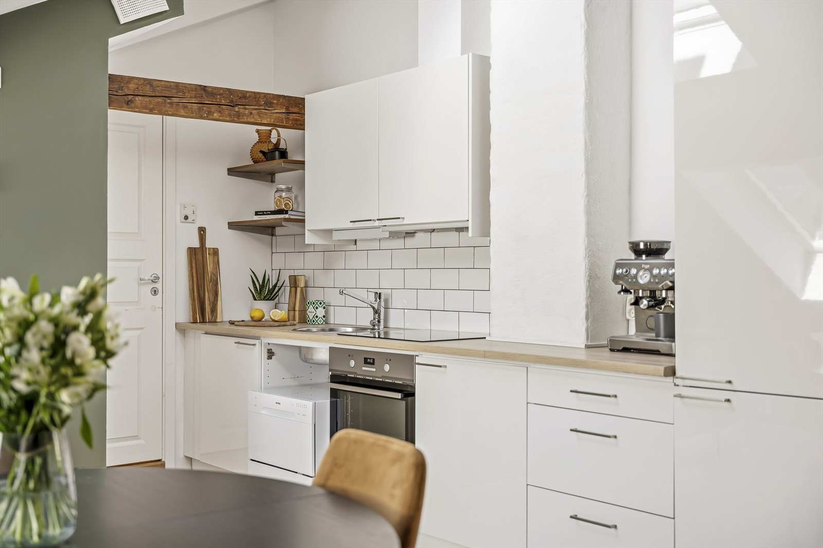 Kjøkkeninnredningen er fra loftsutbyggingen i 2015/2016 med glatte folierte fronter og laminat benkeplate med nedfelt kum i rustfritt stål. Benkeplaten og flisene over benken ble oppgradert i 2019. Galleribilde