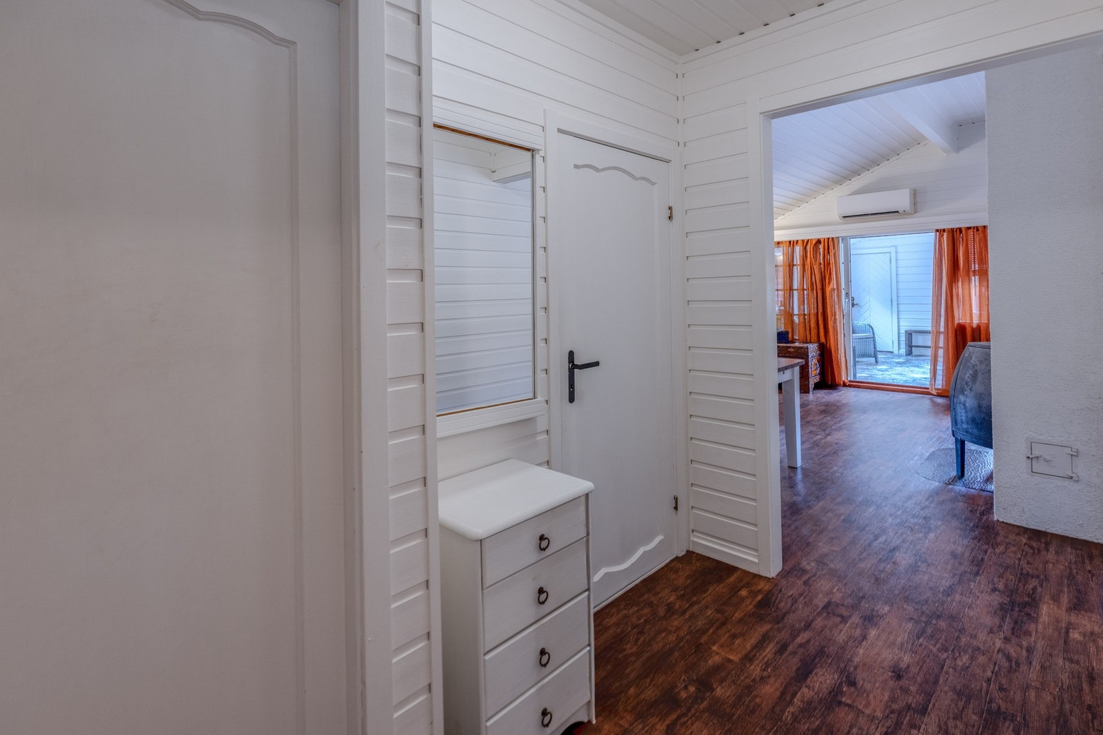 Fra vindfanget ledes du inn i boligens sentrale gang. Overflatene preges av trepanel på vegger og i tak. Galleribilde