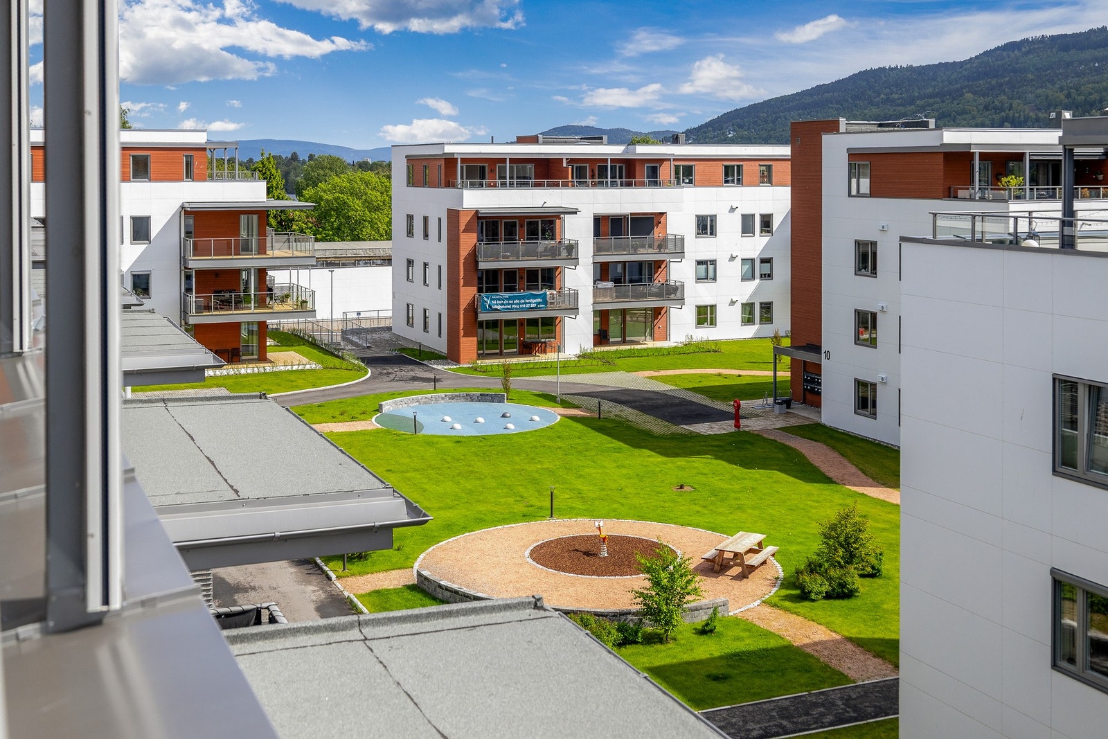 Pent opparbeidede fellesområder med lekeplass, gangstier og beplantninger Galleribilde