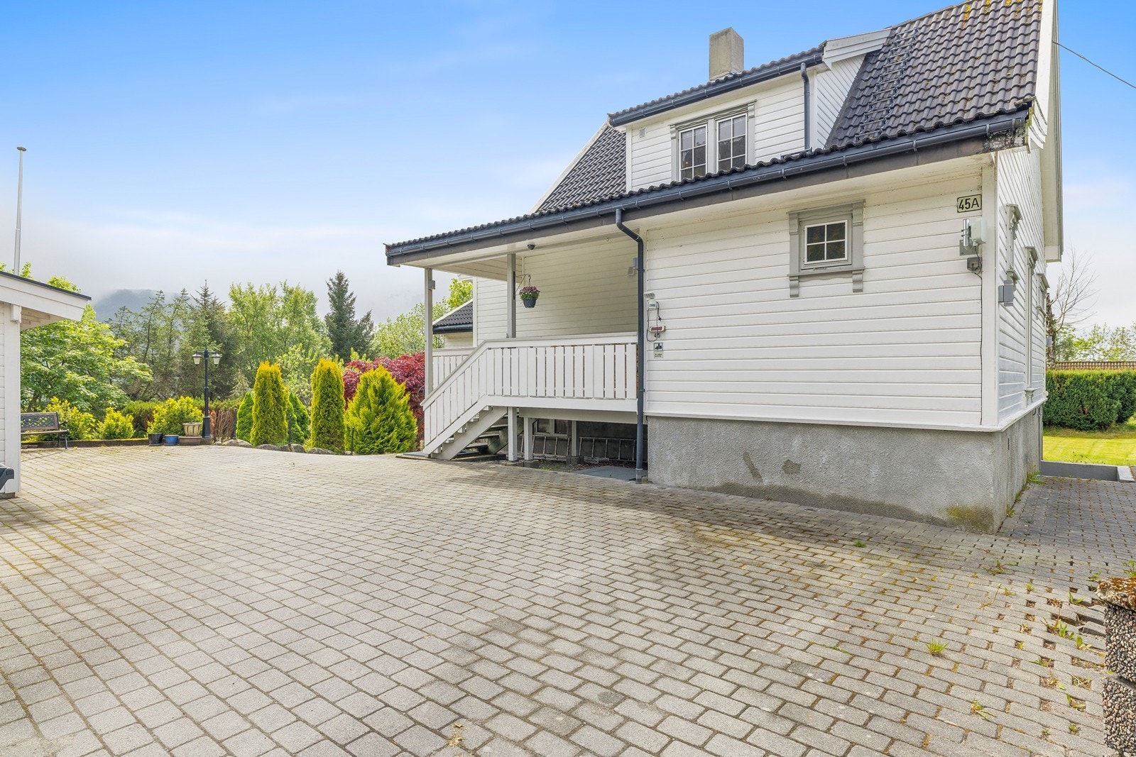 Fin opparbeidet innkjørsel med belegningsstein og god plass til parkering. Her i tunet føler man seg hjemme umiddelbart! Galleribilde