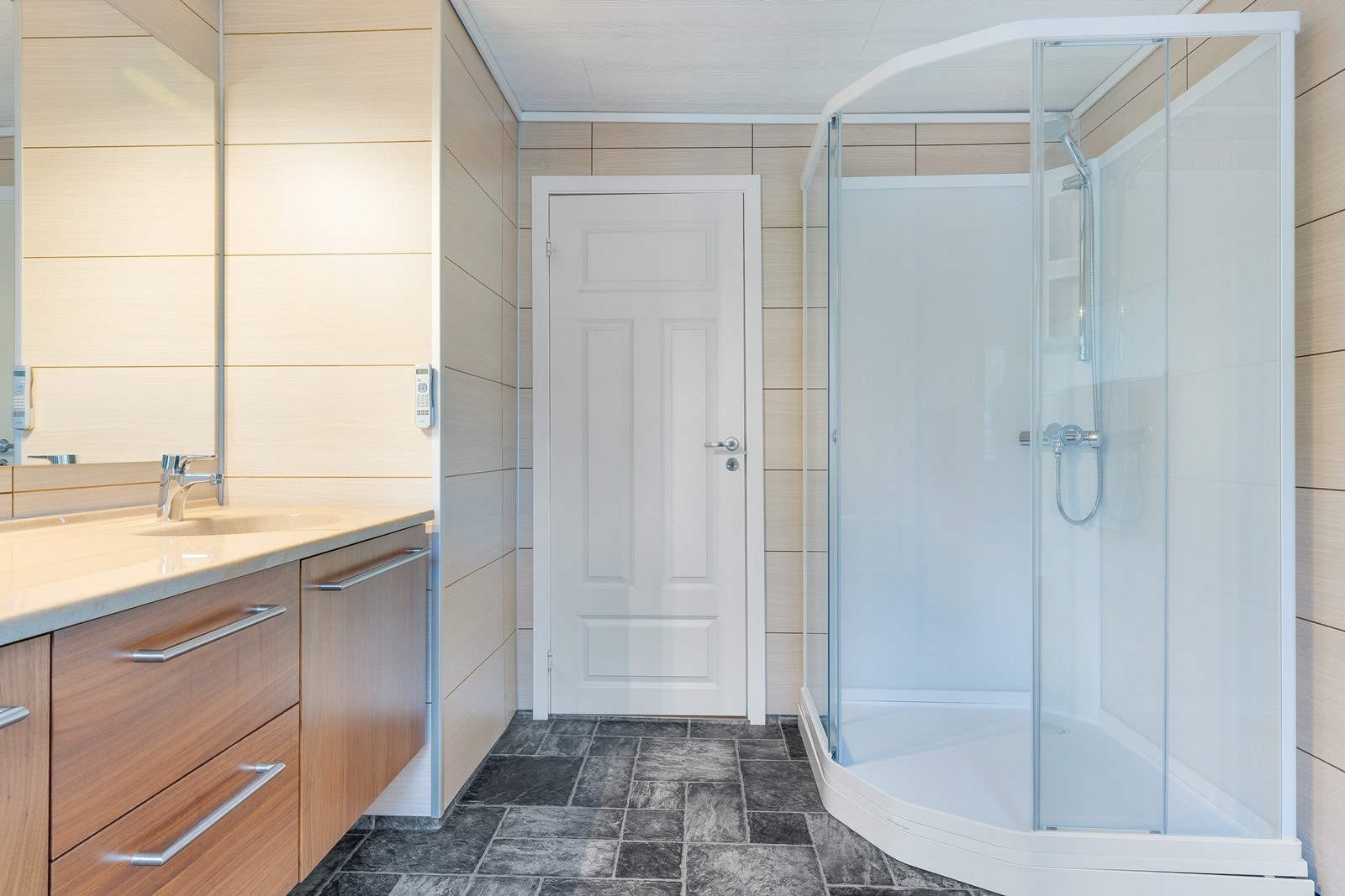 Egen dusjsone med glassvegger gir et ryddig og praktisk bad. Badet er av nyere dato, men ukjent byggeår. Galleribilde