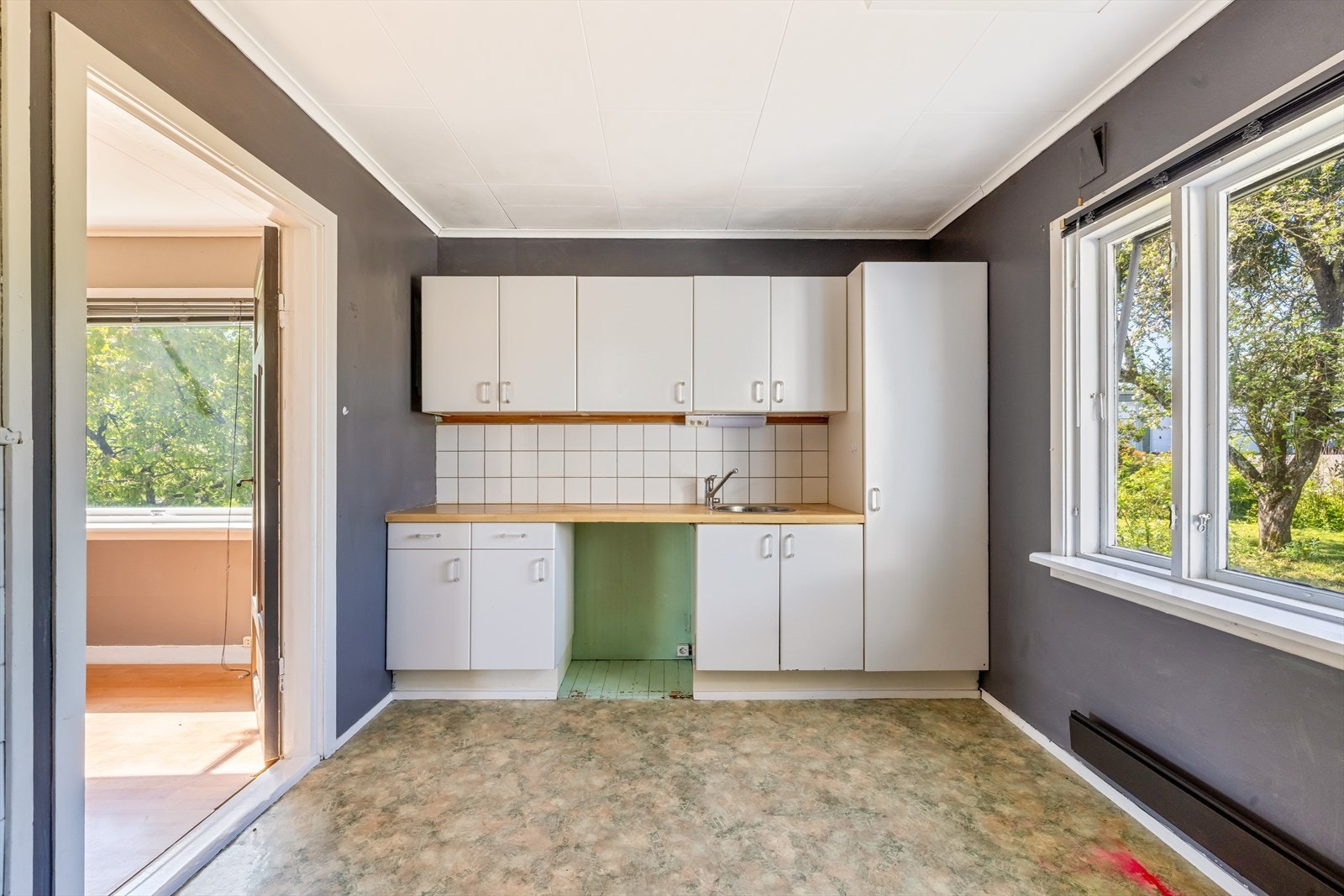 Kjøkkenet er praktisk plassert i egen sone og har kjøkkeninnredning i malt utførelse og laminat benkeplate med nedfelt benkebeslag/kum. Galleribilde