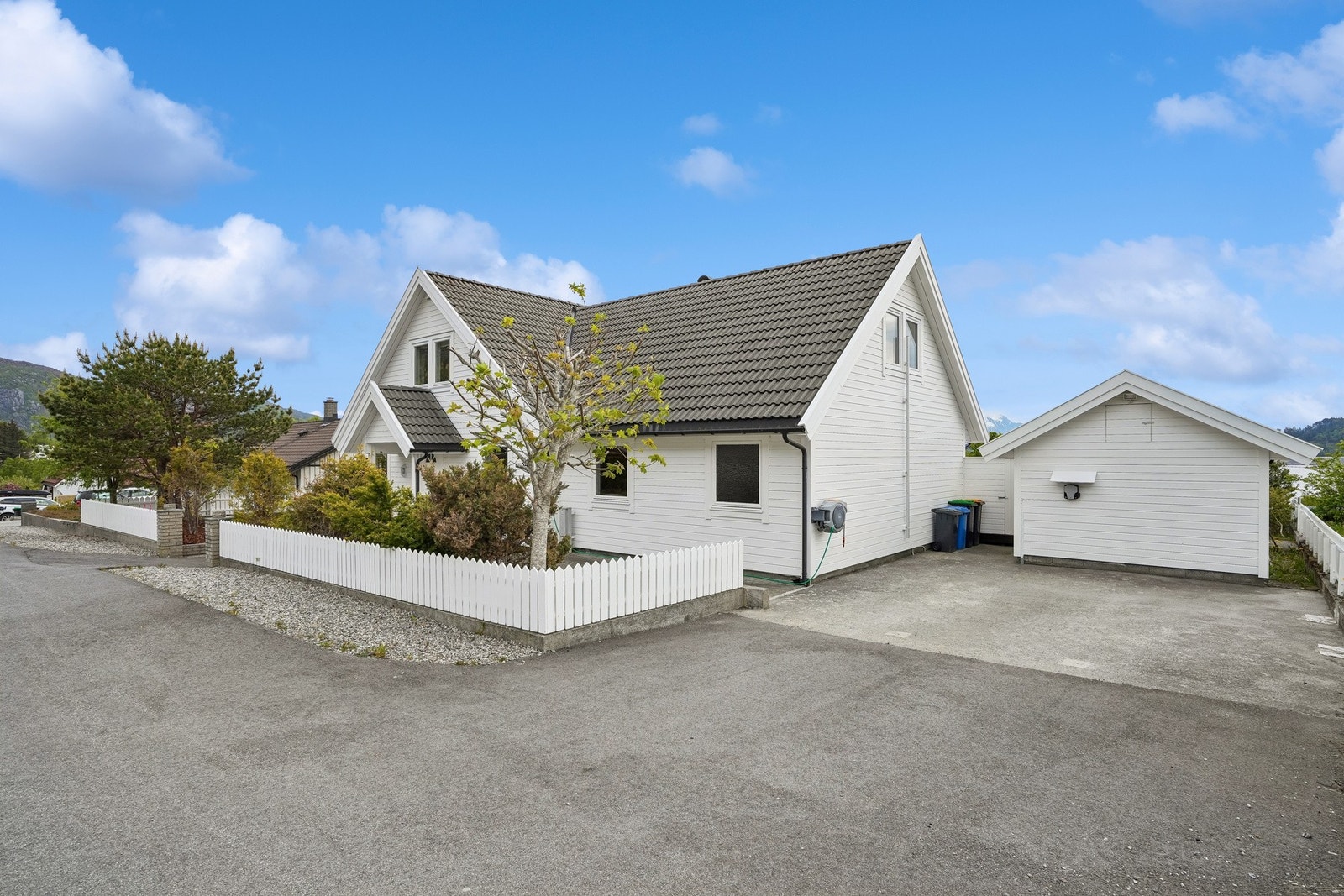 Det er god plass til parkering på eiendommen og elbil-lader montert på uthus. Galleribilde