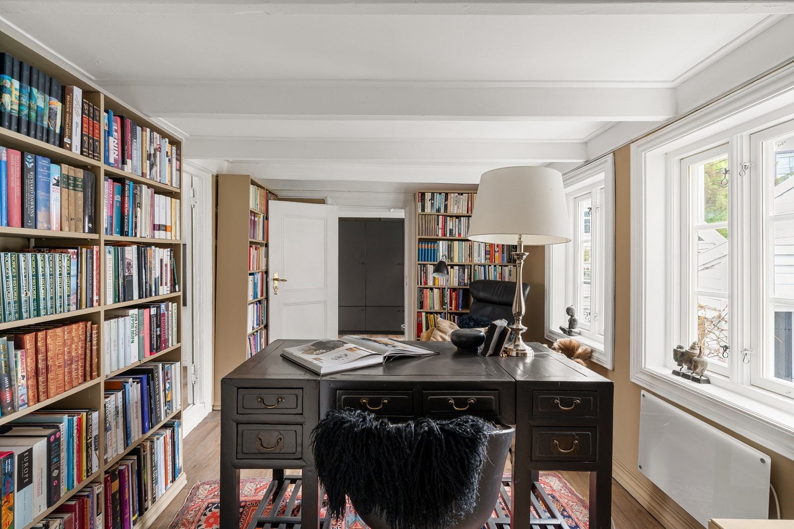 Innbydende bibliotek med plassbygde bokhyller og en lun atmosfære. Galleribilde