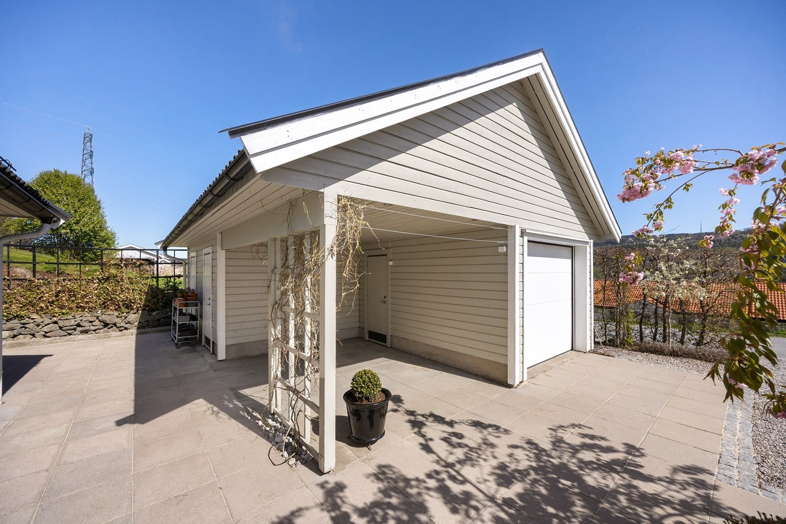 Frittstående garasje med tilhørende carport gir gode parkeringsmuligheter. Galleribilde