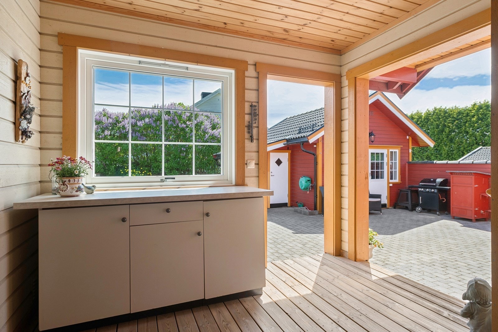 Det er etablert innredning med benke- og skapplass i tilknytning til det overbygde inngangspartiet - perfekt for tilberedning av mat. Galleribilde