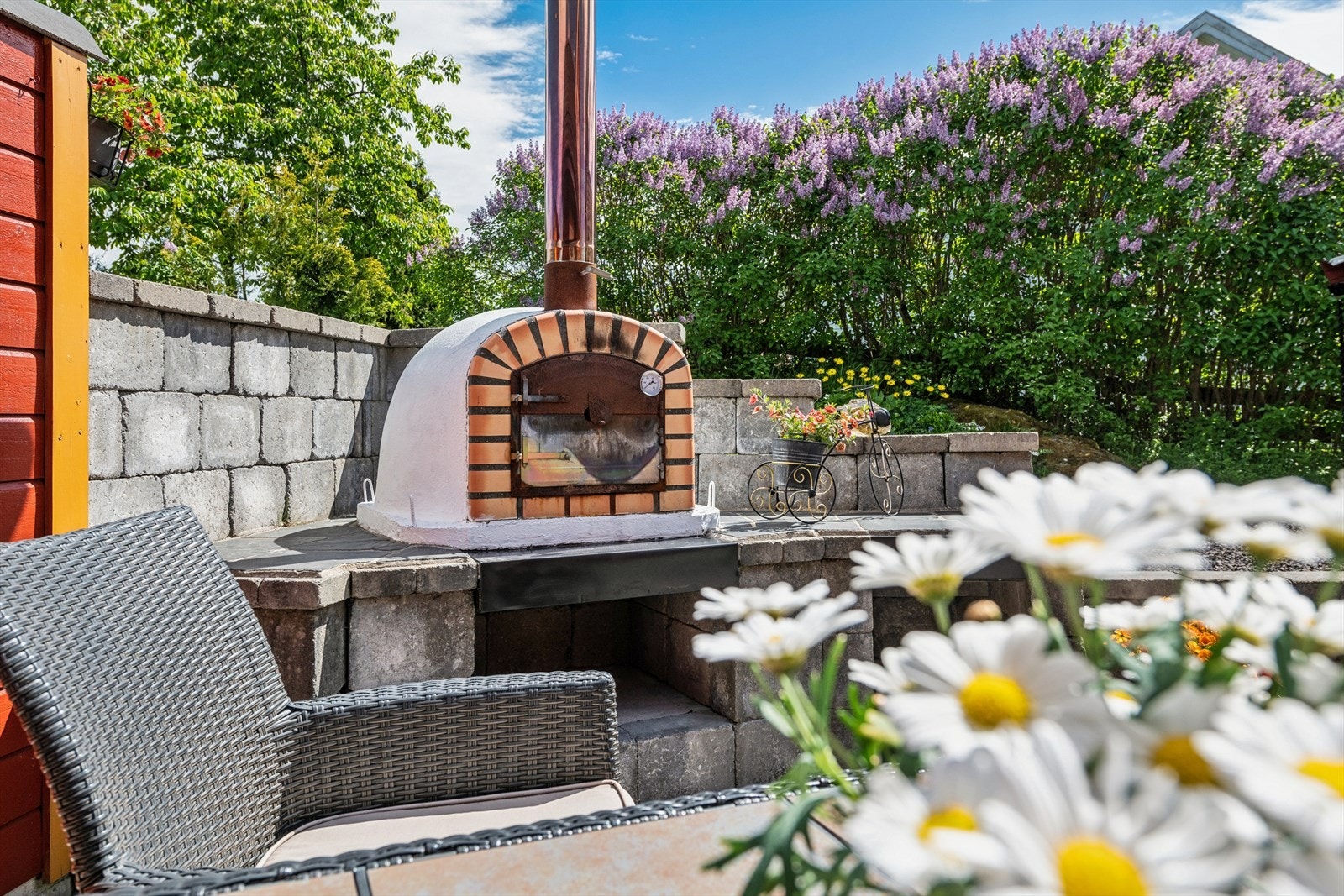 Tomten har frodig og variert beplantning , med en vakker syrinhekk som blomstrer og dufter nydelig i sommermånedene. Galleribilde