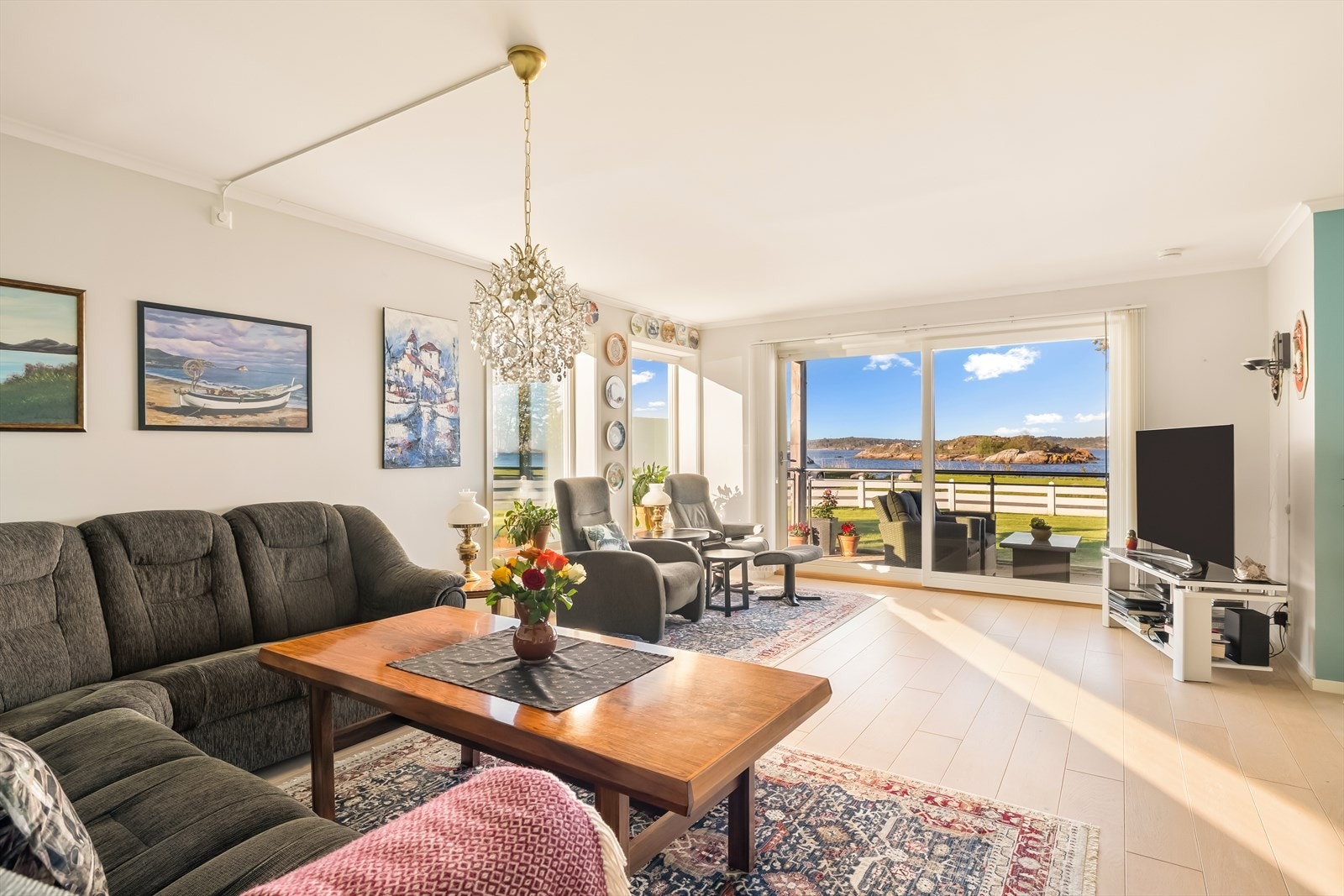 Store vindusflater og skyvedør i glass gir rikelig med naturlig lys inn i stuen. Galleribilde