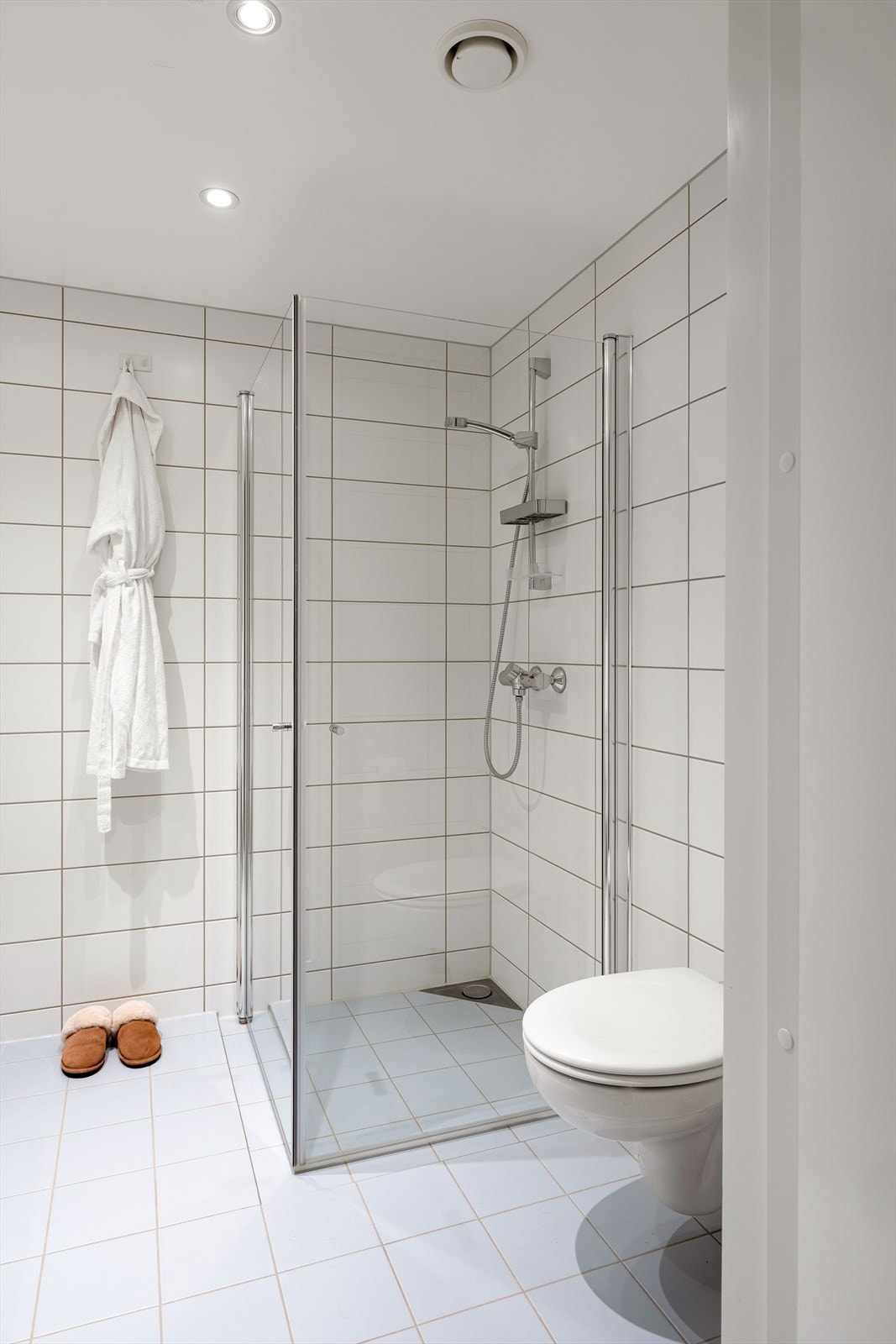 Badet har varme i gulv og er innredet med vegghengt toalett, dusjhjørne, vask i seksjon, speil med belysning og opplegg for vaskemaskin. Galleribilde