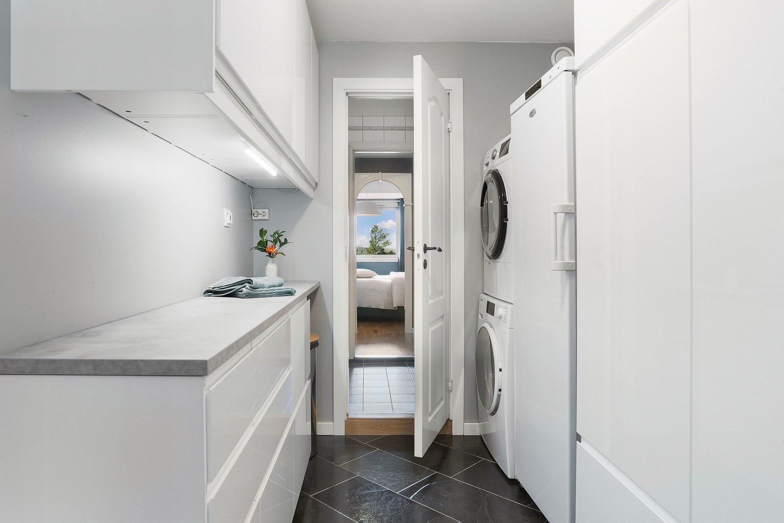 Praktisk mellomgang med opplegg for vaskemaskin og god benkeplass. Galleribilde