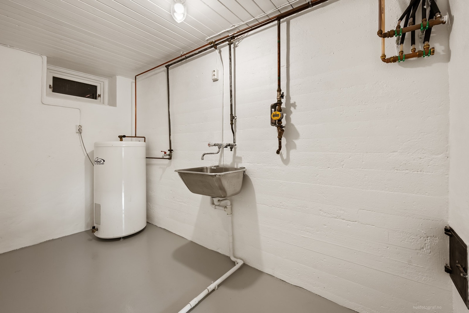 Praktisk vaskerom med utslagsvask, opplegg for vaskemaskin og en varmtvannsbereder på 198 liter. Galleribilde