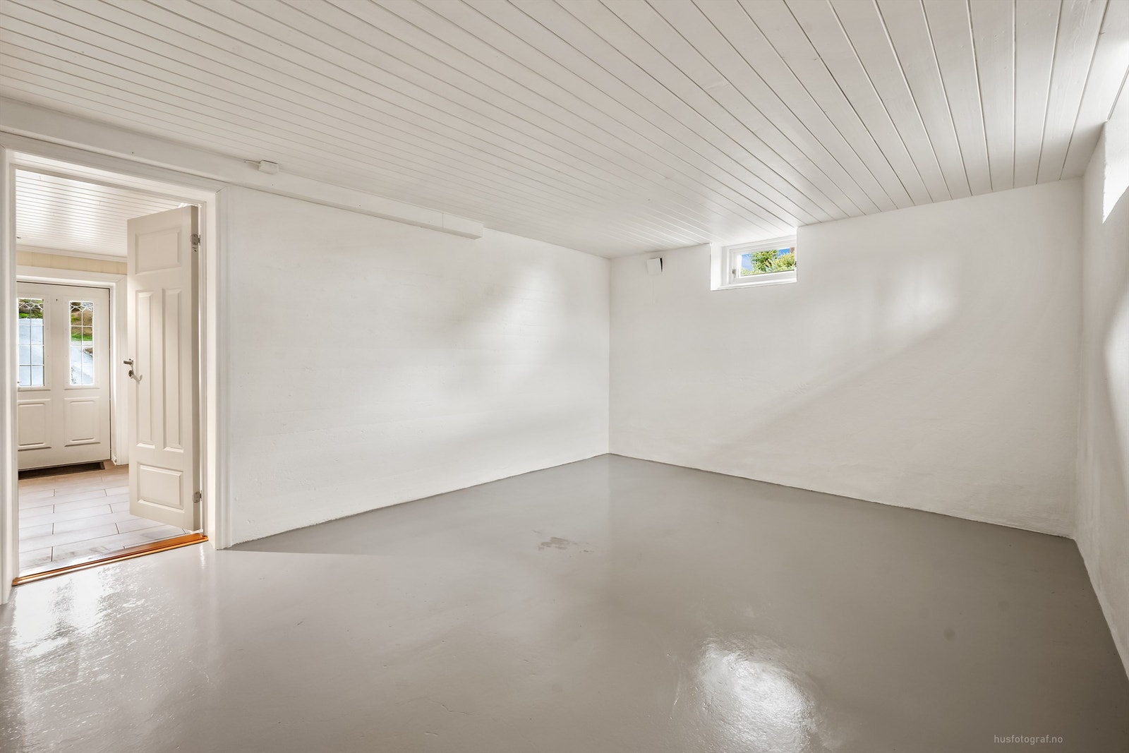 Bodene har malt betonggulv og panel i taket. Galleribilde