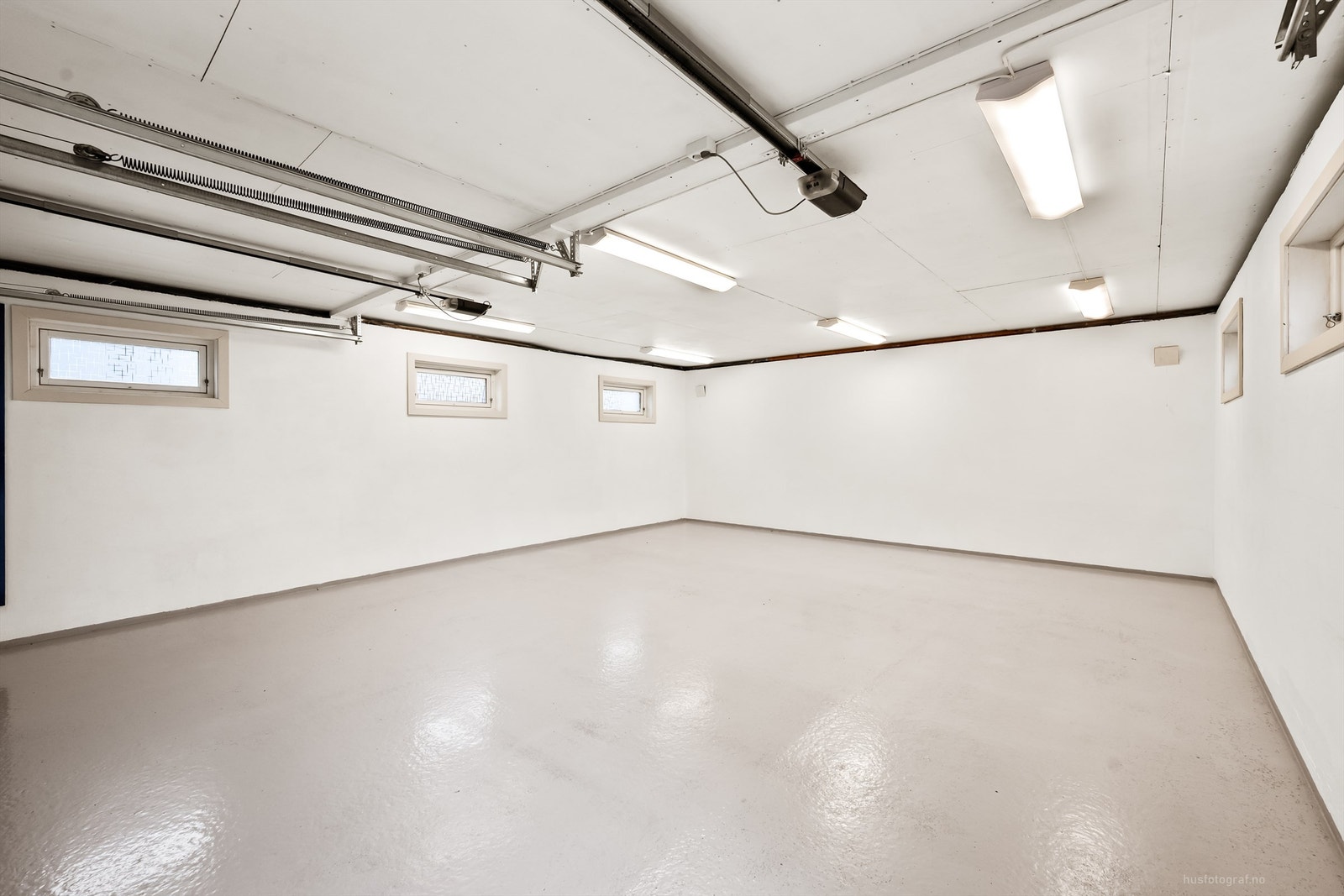 Garasjen har støpt dekke, innlagt strøm, belysning og to elektriske leddporter i metall. Galleribilde