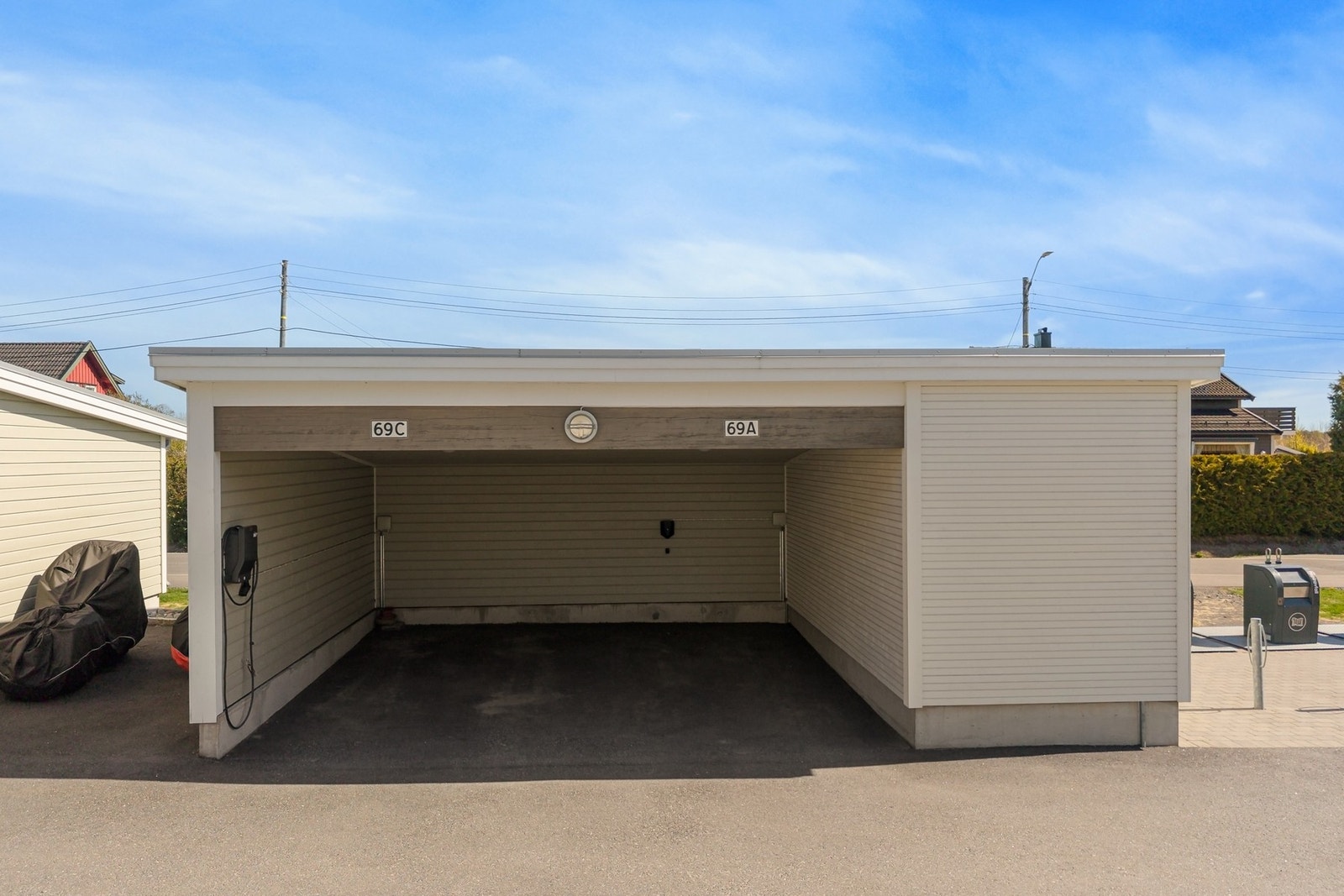 Parkering i carport med låsbar el-bil lader. Det er også utvendig bod. Galleribilde