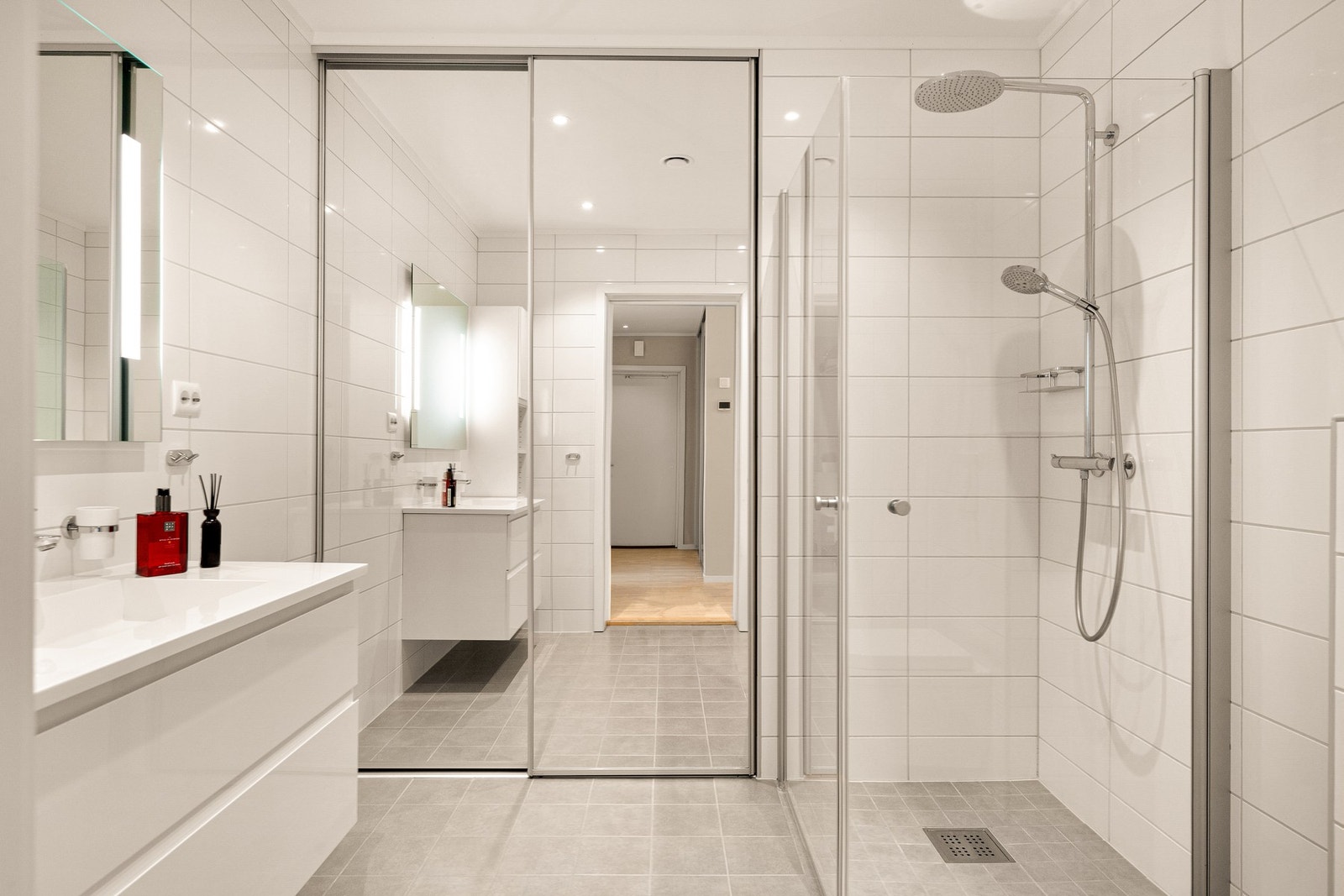 Badet er innredet med servant, veggmontert toalett, dusjvegger/hjørne og opplegg for vaskemaskin. Galleribilde