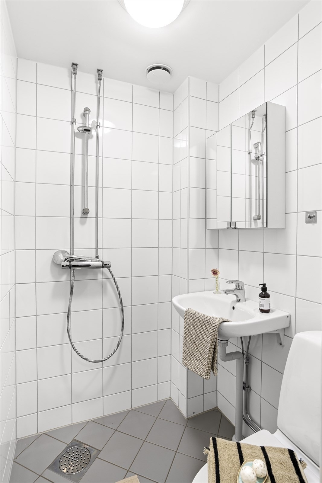 Baderommet er flislagt med gulvvarme og har ett praktisk dusjhjørne for optimal plassbruk. Galleribilde