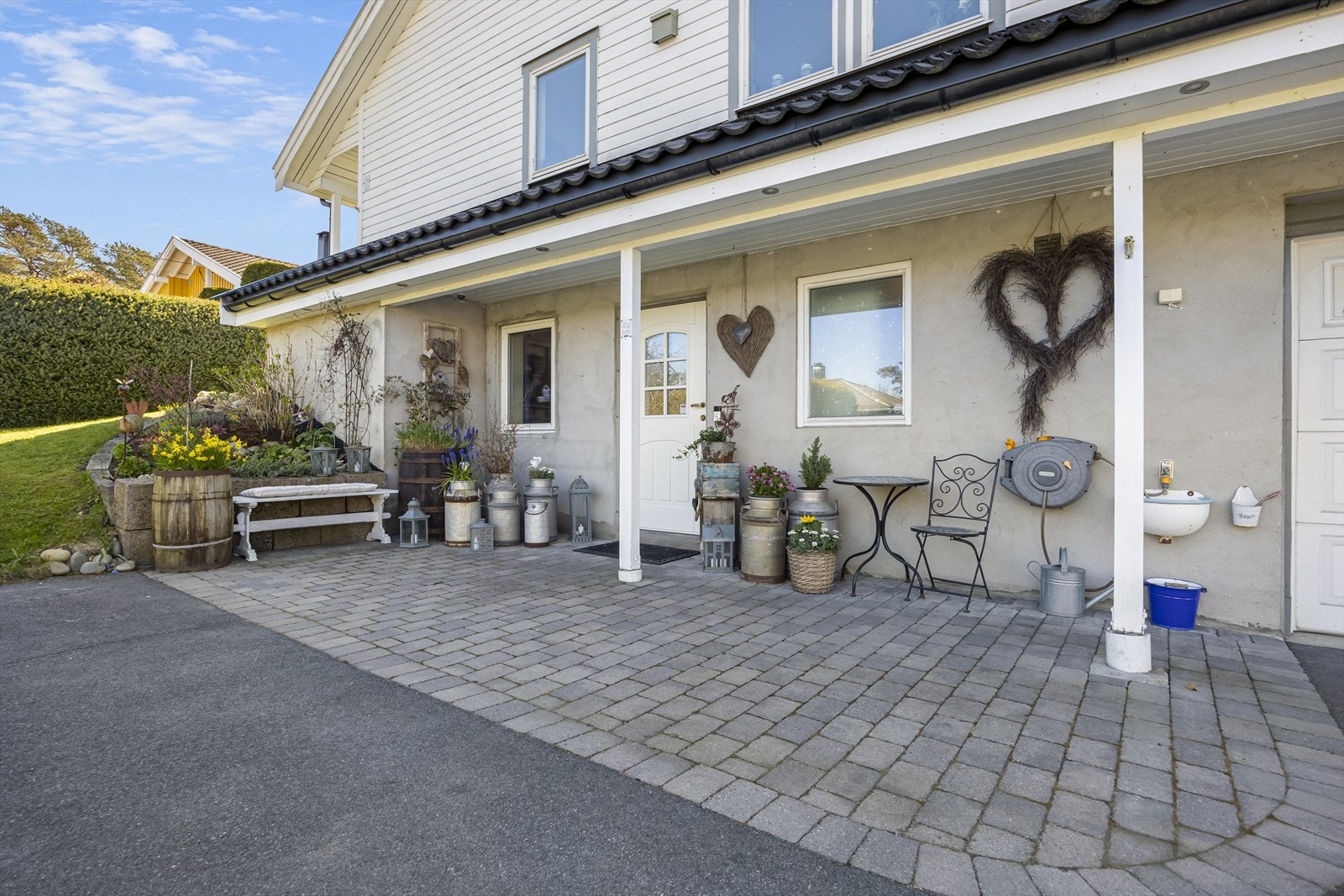 Pent opparbeidet tomt med belegningsstein ved inngangsparti. Galleribilde