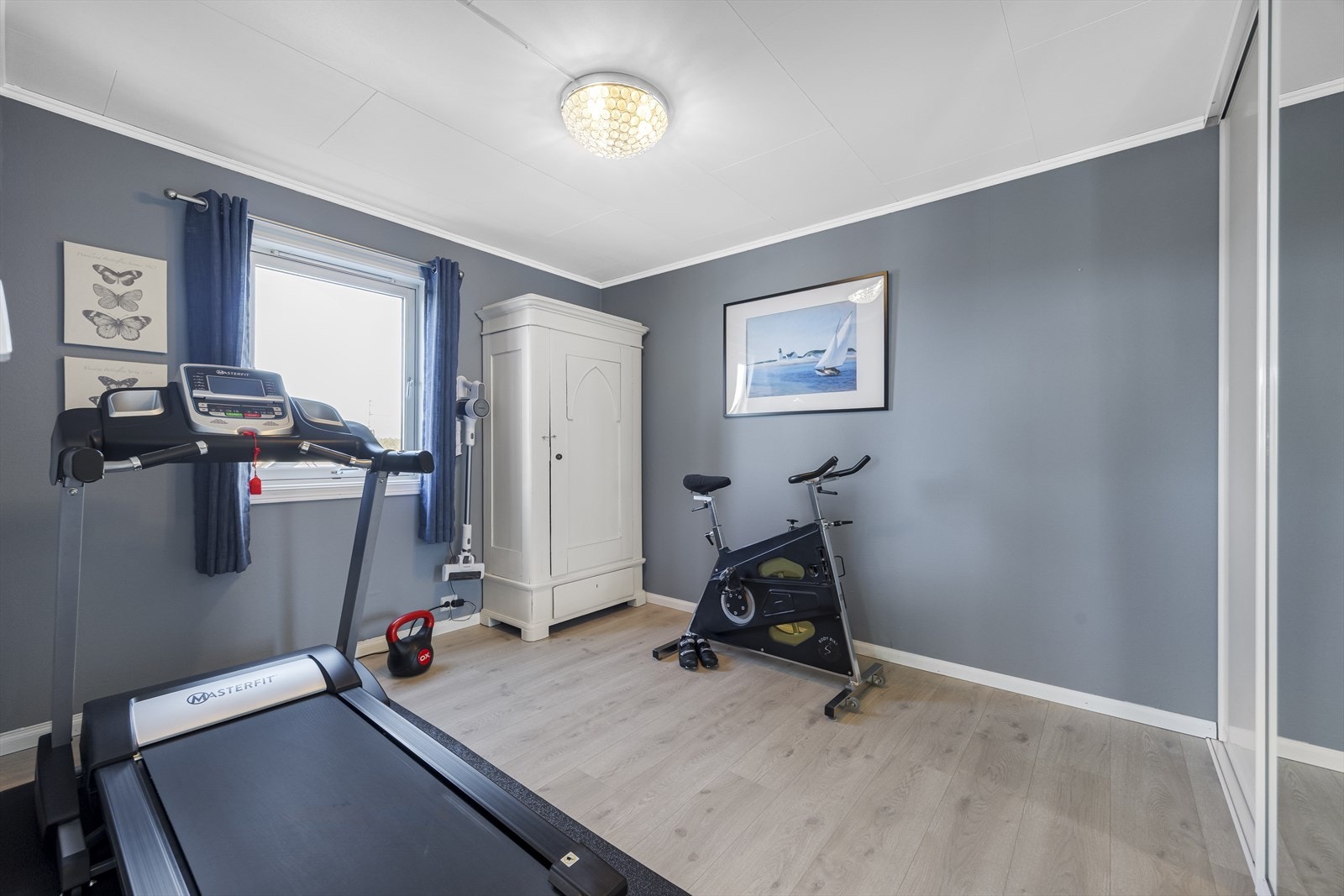 Dette er soverom to i hovedetasje, benyttes i dag som treningsrom. Skyvedørsgarderobe gir praktiske oppbevaringsmuligheter i rommet. Galleribilde