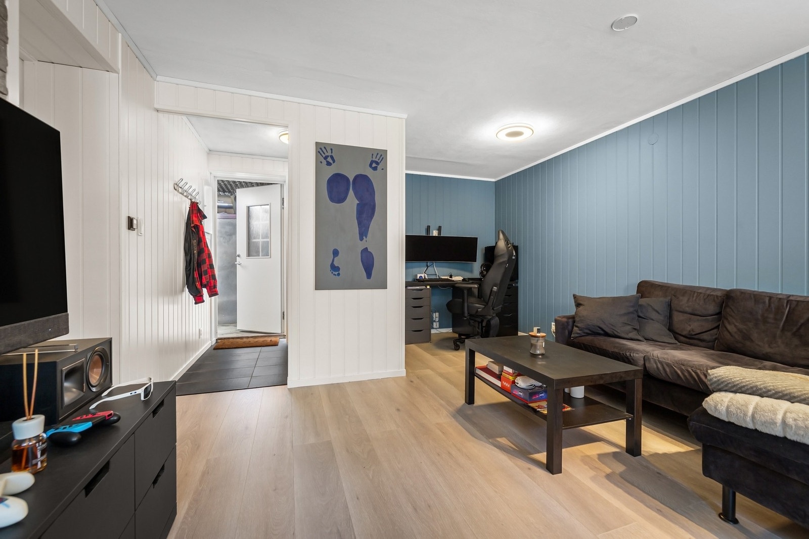 Stuen i underetasjen og gangen ut til trapp. Galleribilde