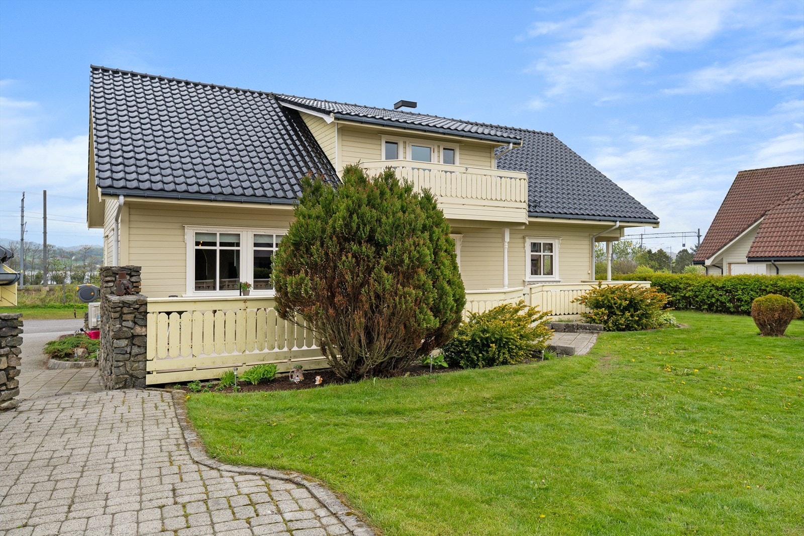 Tomten er pent opparbeidet med plen og hekk som rammer inn eiendommen. Galleribilde