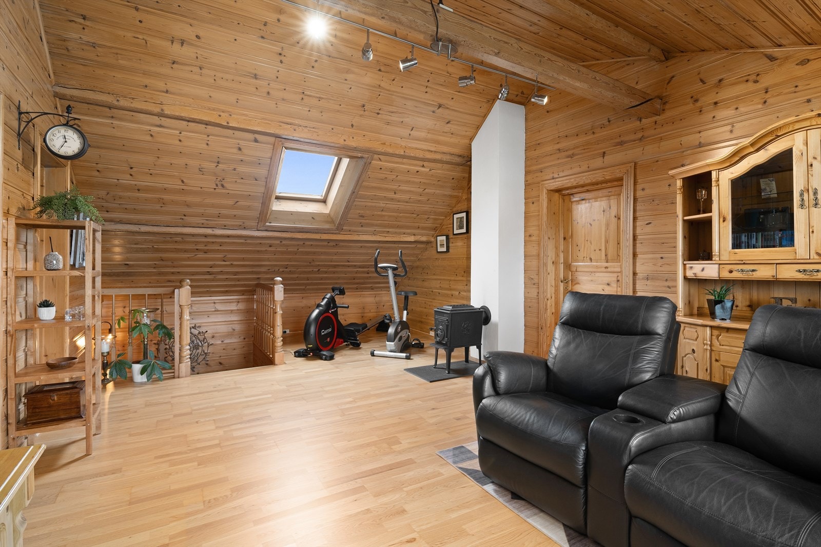 Loftstuen er et allsidig rom med plass til både sofagruppe og treningsapparater. Takvinduet gir godt med lys. Galleribilde