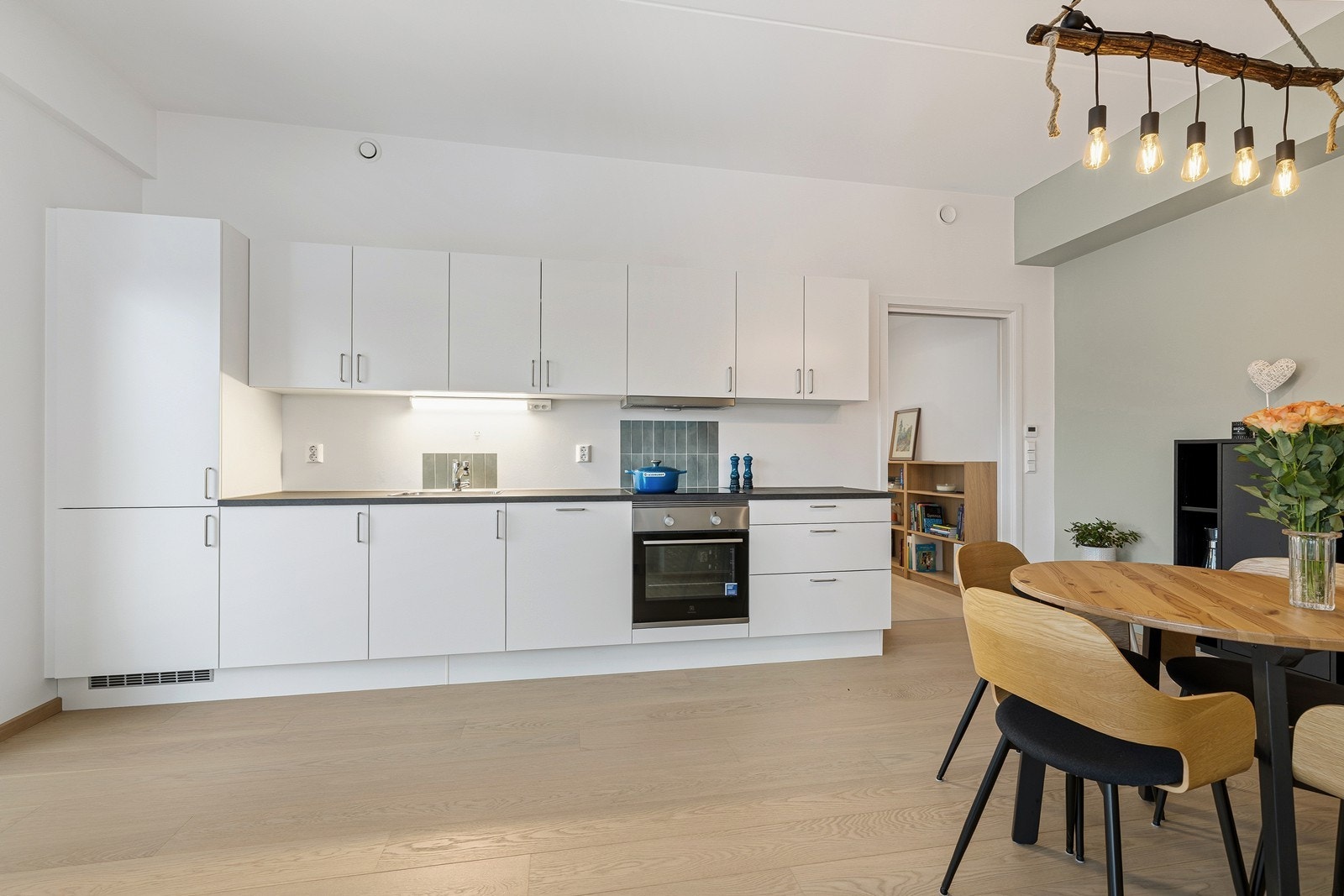 Klassisk og elegant kjøkkeninnredning med hvite slette fronter og benkeplate av laminat. Galleribilde