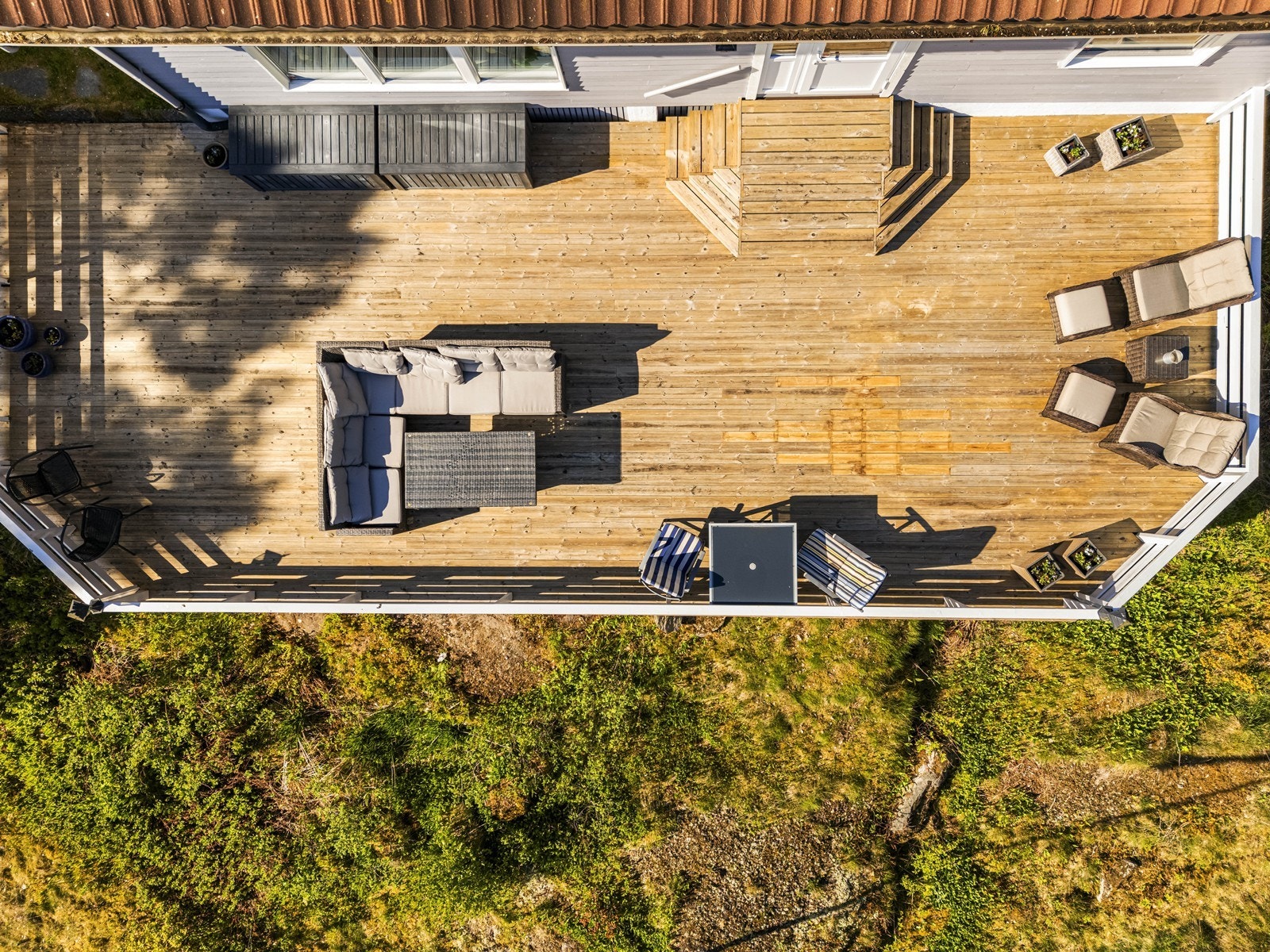 Terrassen strekker seg rundt store deler av huset og gir fleksible soner for uteliv. Galleribilde