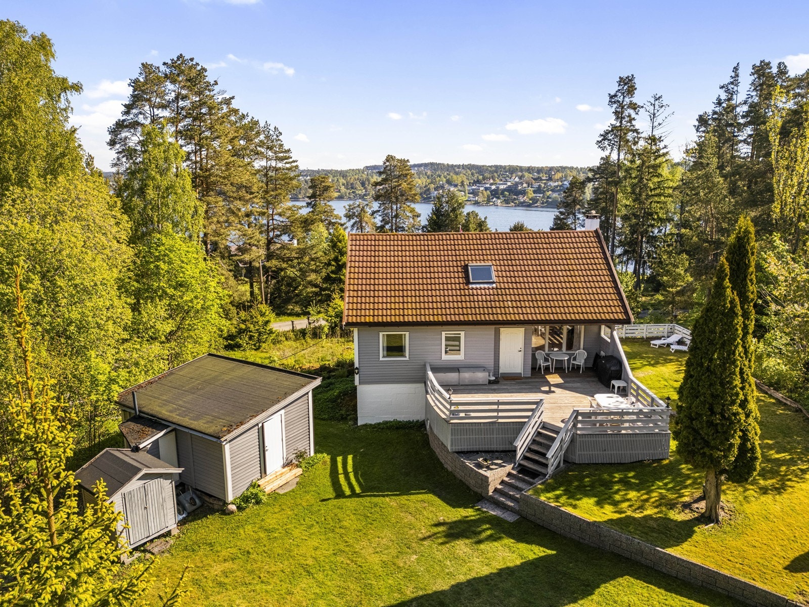 Boligen og annekset sett fra luften, med sjøen i bakgrunnen. Galleribilde
