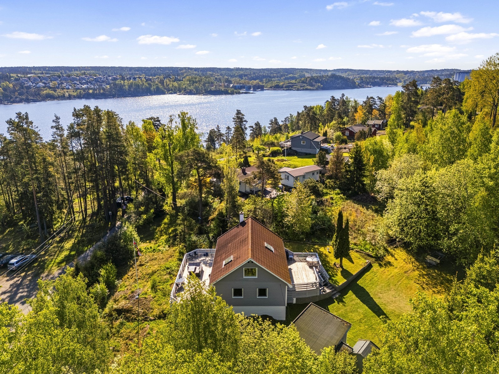 Eiendommen ligger høyt og fritt med utsikt over sjøen, omgitt av grønn og frodig natur. Galleribilde