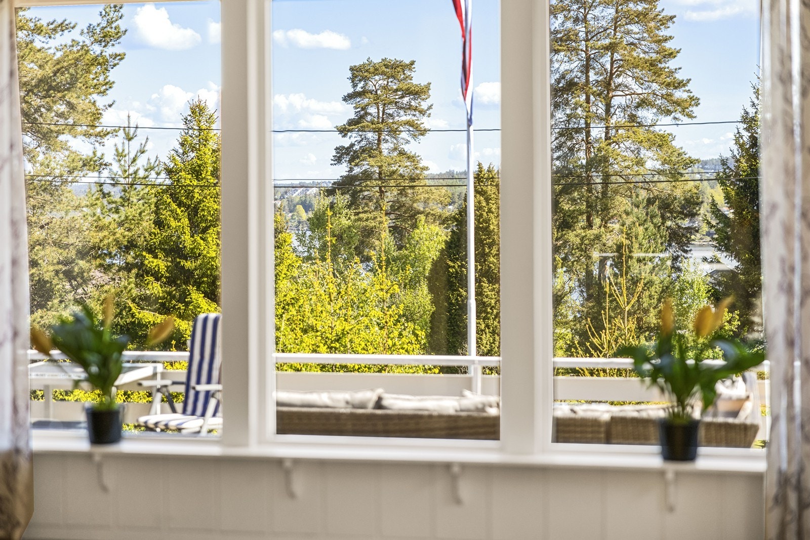 Utsikt fra stuevinduet mot terrassen og naturen utenfor. Galleribilde