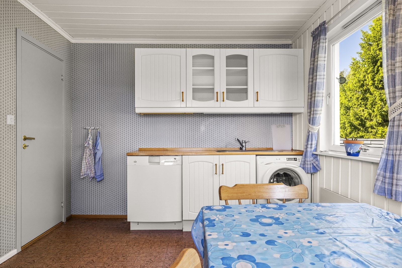 Kjøkkeninnredningen har profilerte fronter og opplegg for både oppvaskmaskin og vaskemaskin. Galleribilde