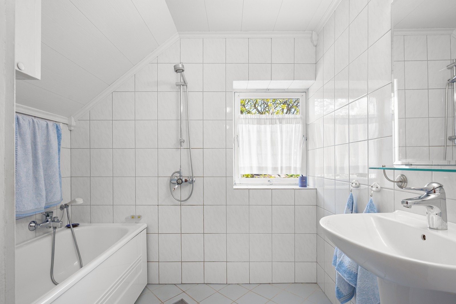 Badet er innredet med badekar, dusj, servant og speil. Galleribilde