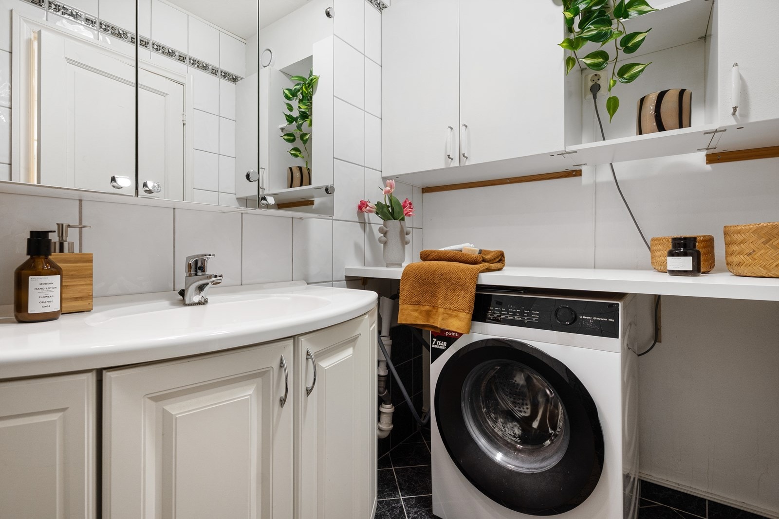 Det er praktisk innredet som både bad og vaskerom. Her er det plass til både vaskemaskin og tørketrommel. Galleribilde
