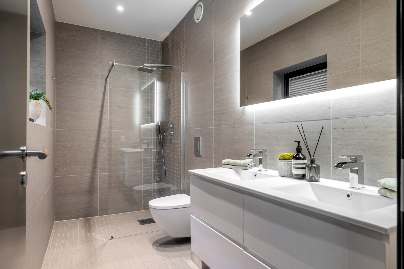 Badet som ligger tilknyttet hovedsoverommet har innredning med heldekkende dobbelservant fra Scala. Videre har badet vegghengt toalett, eksklusivt speil fra Duravit med bakbelysning, og dusjnisje med vegg i herdet glass Galleribilde