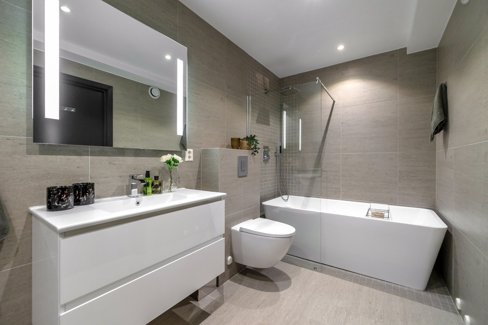 Badet på plan to er lekkert med fliser på vegger og gulv, samt mosaikkfliser og stort badekar Galleribilde