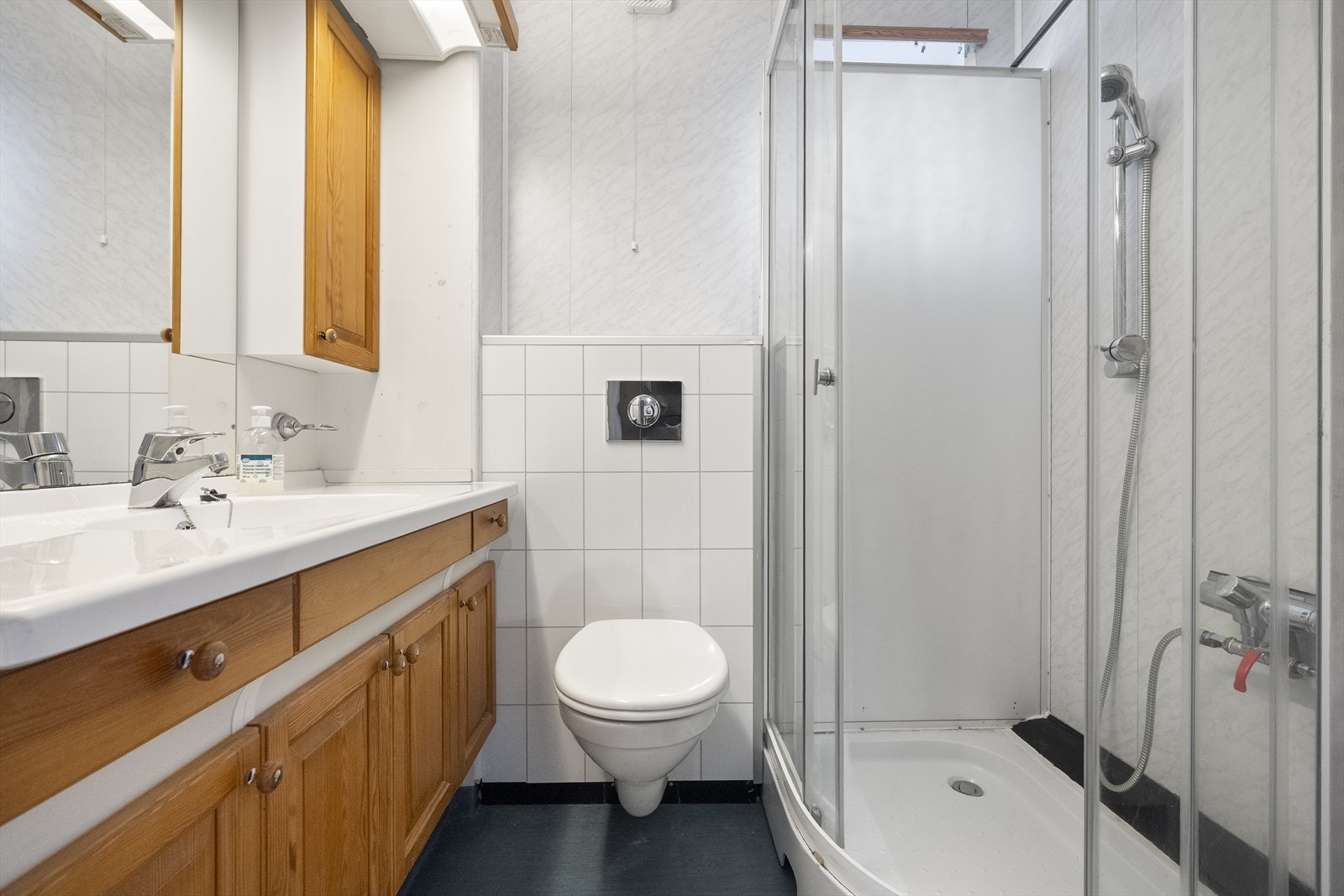 Badet i første etasje er utstyrt med dusjhjørne, servantinnreiing og vegghengt klosett. Galleribilde