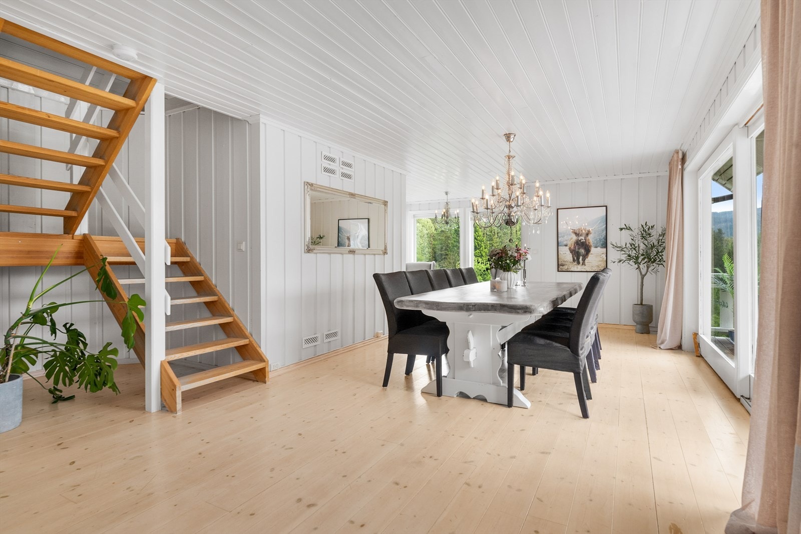 Romslig stue og spisestue med tregulv og panel i taket. Galleribilde