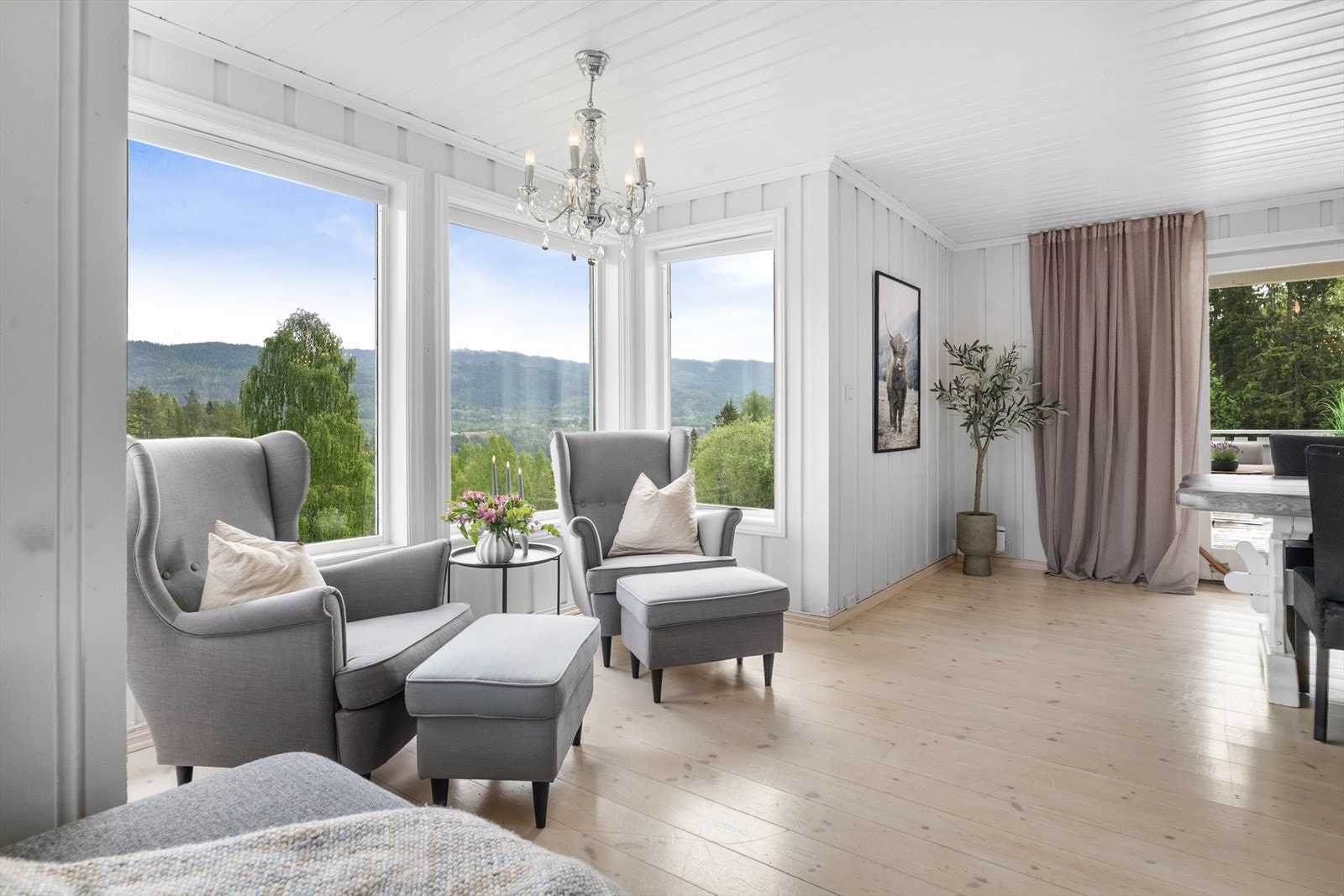 Stuen har store vindusflater som gir rikelig med lys og rammer inn utsikten. Galleribilde
