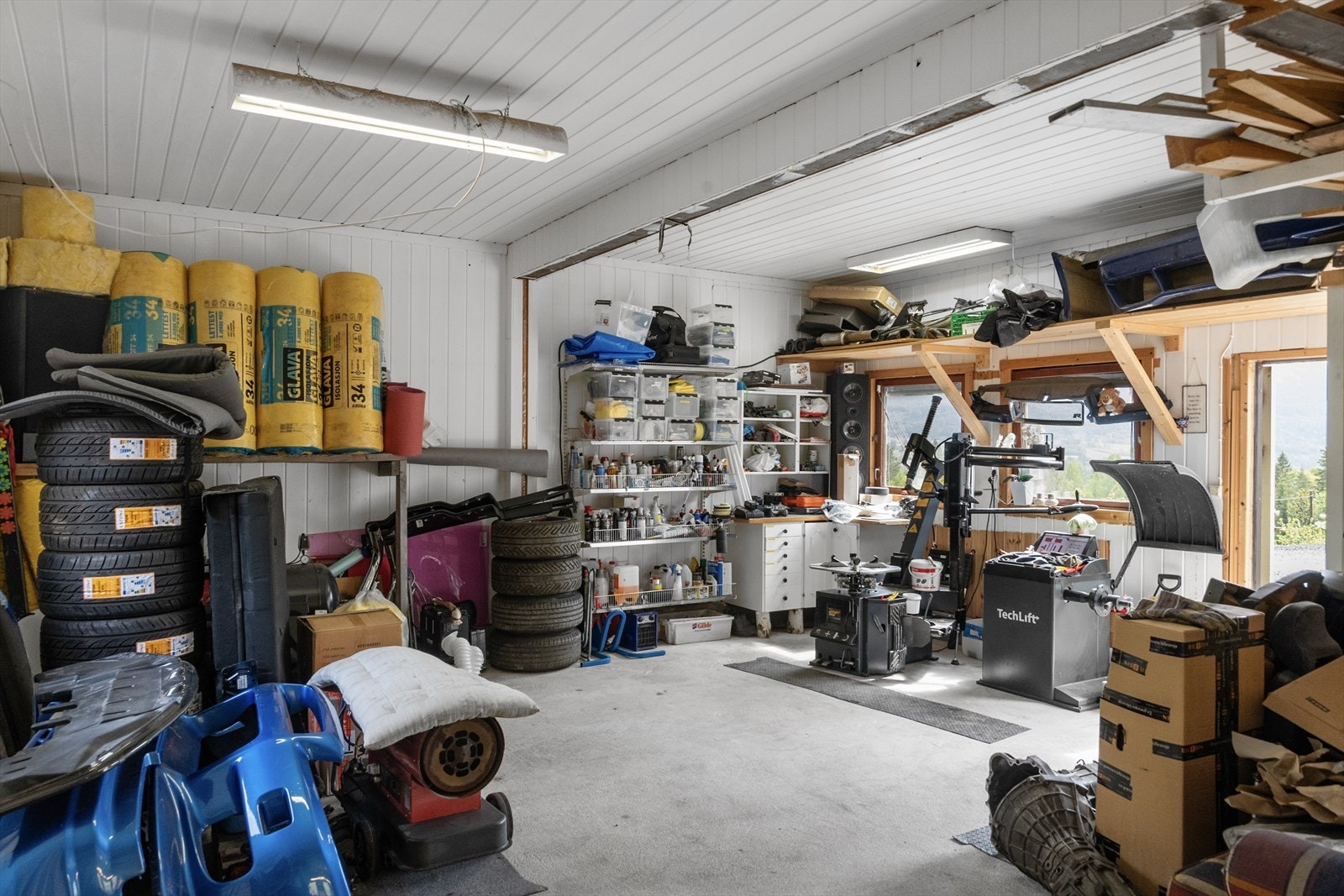 Bygningen har støpt plate på mark og er innredet med hyller og arbeidsbenk. Galleribilde