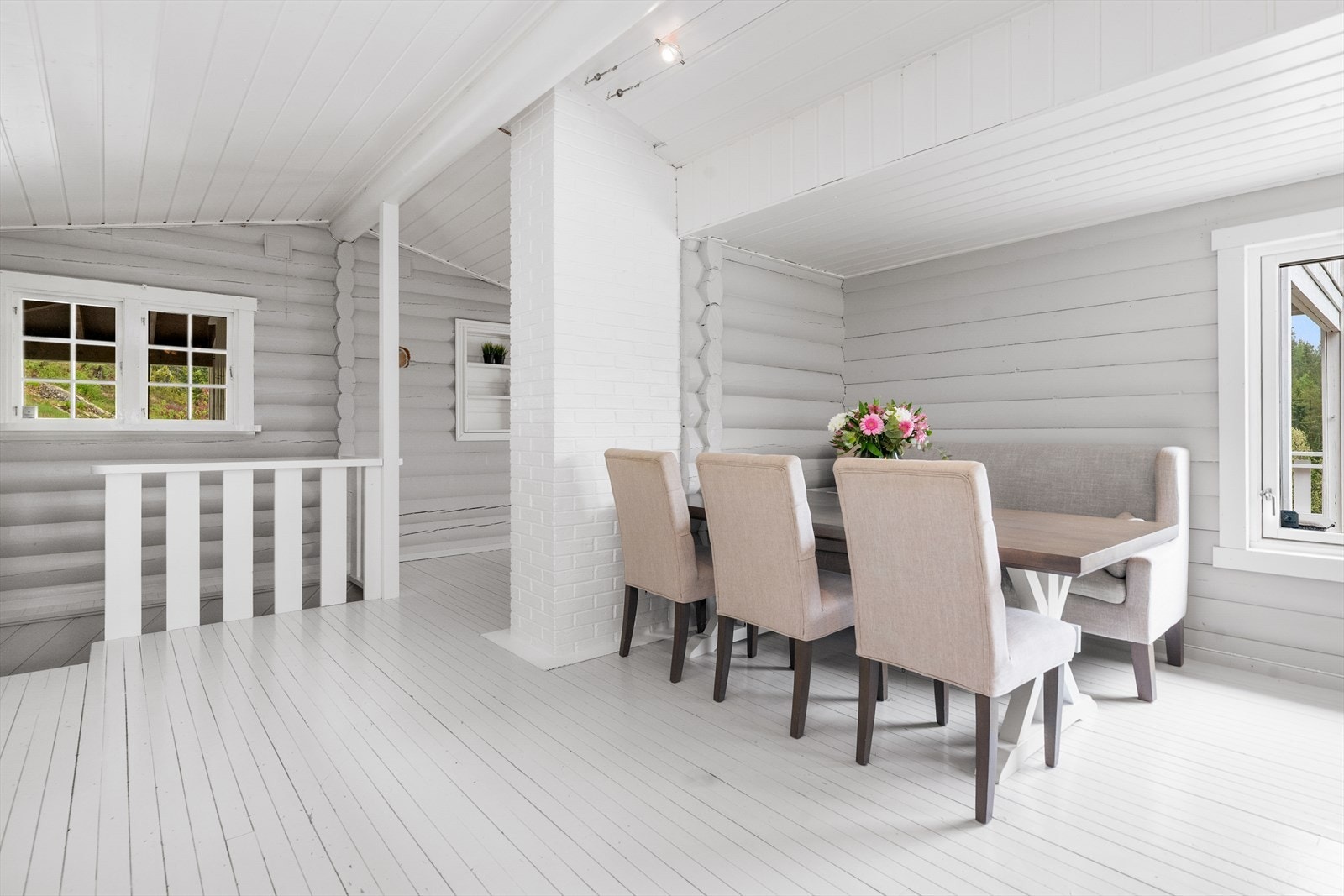 Spiseplass i tilknytning til kjøkkenet, med malte tømmervegger og tregulv. Galleribilde