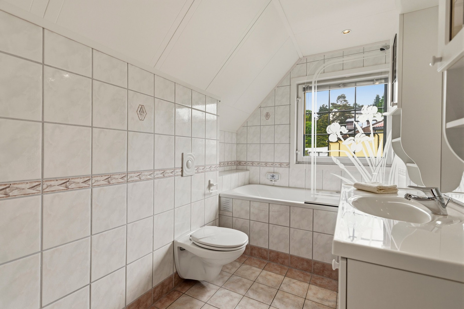 Badet er utstyrt med servant, klosett og badekar, samt varmekabler i gulvet Galleribilde