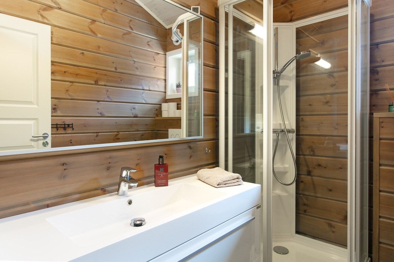 Detaljer fra badet, med heldekkende servant og godt med oppbevaringsplass. Galleribilde