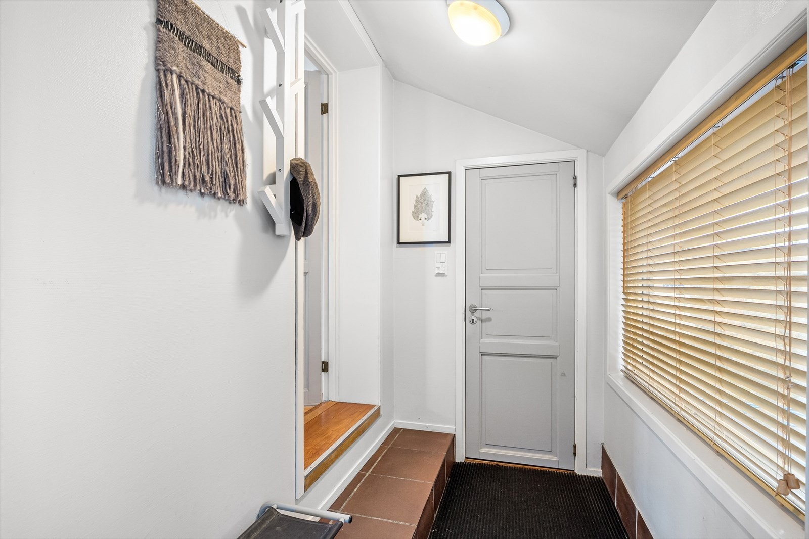 Du kommer inn i en lys entré med plass til å henge fra seg. Galleribilde