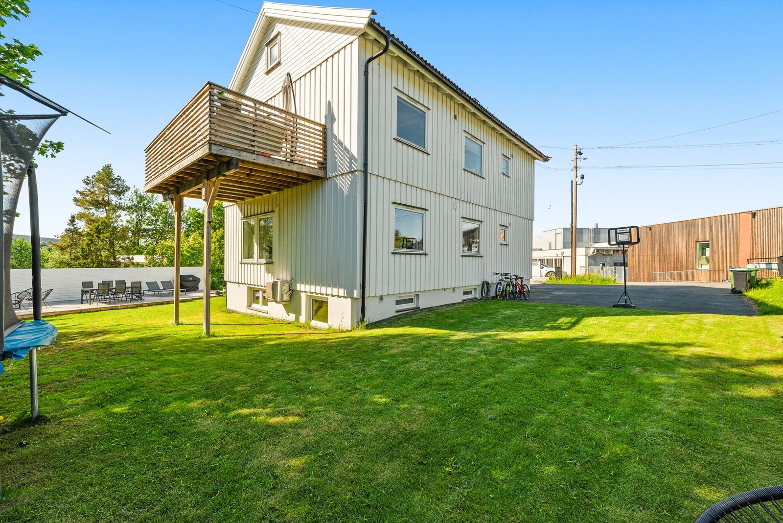 Fasade og hage - boligen ligger i en tomannsbolig med pent plenareal, gode uteområder og balkong/veranda tilknyttet hovedplanet i 2. etasje. Galleribilde