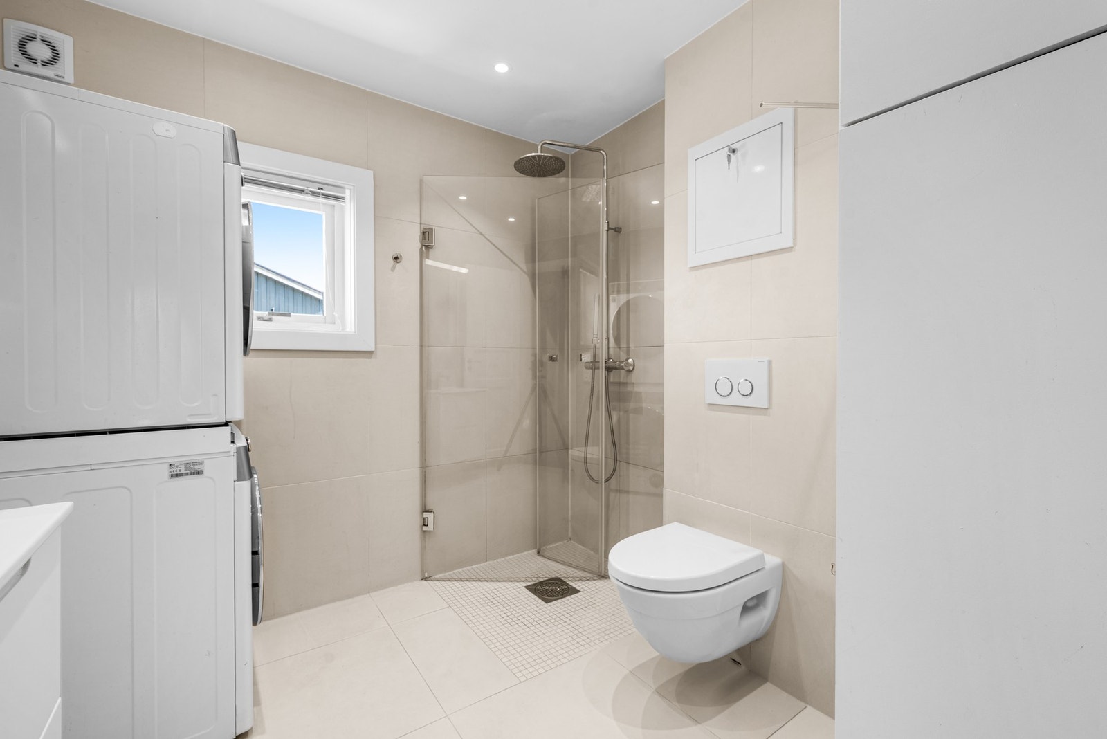 Badet er utstyrt med servantinnredning, dusj på gulv, opplegg for vaskemaskin og varmekabler i gulv. Galleribilde