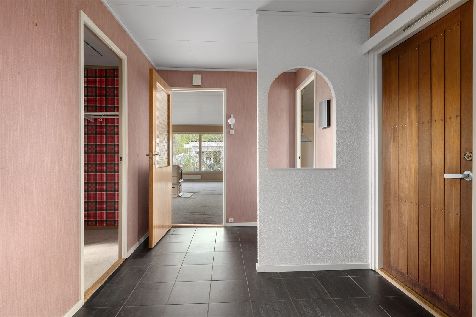 Romslig entré med flislagt gulv og direkte tilgang til stue og garderobe. Galleribilde