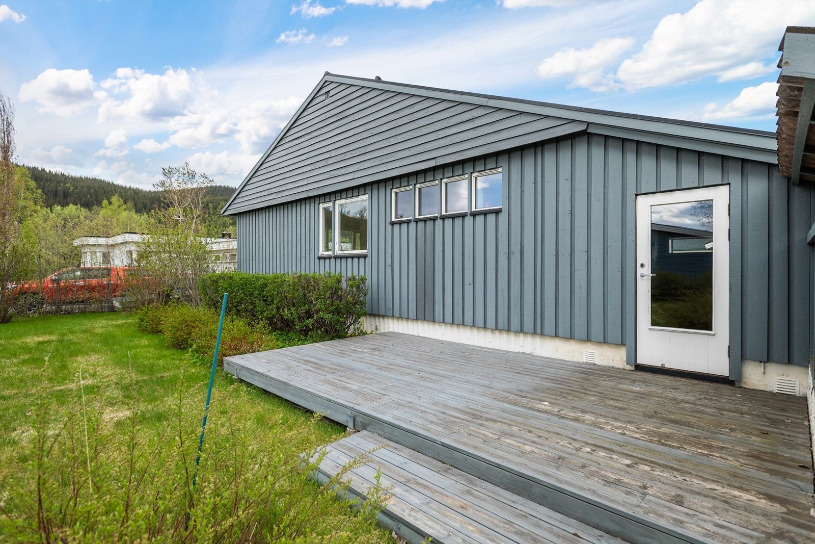 Markterrasse på cirka 16,6 m2 ved fasaden mot vest, med levegg mot sør for skjerming. Galleribilde