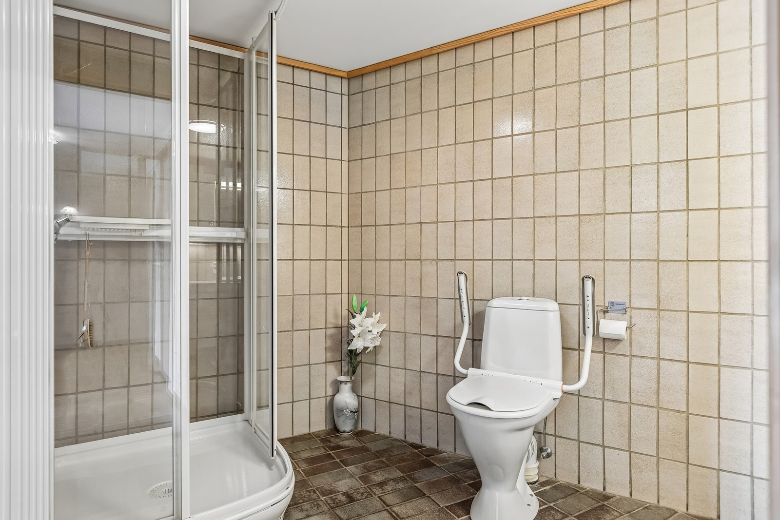Badet måler 6,5 kvm og er innredet med dusjkabinett, toalett, samt servant med skap og speil. Galleribilde